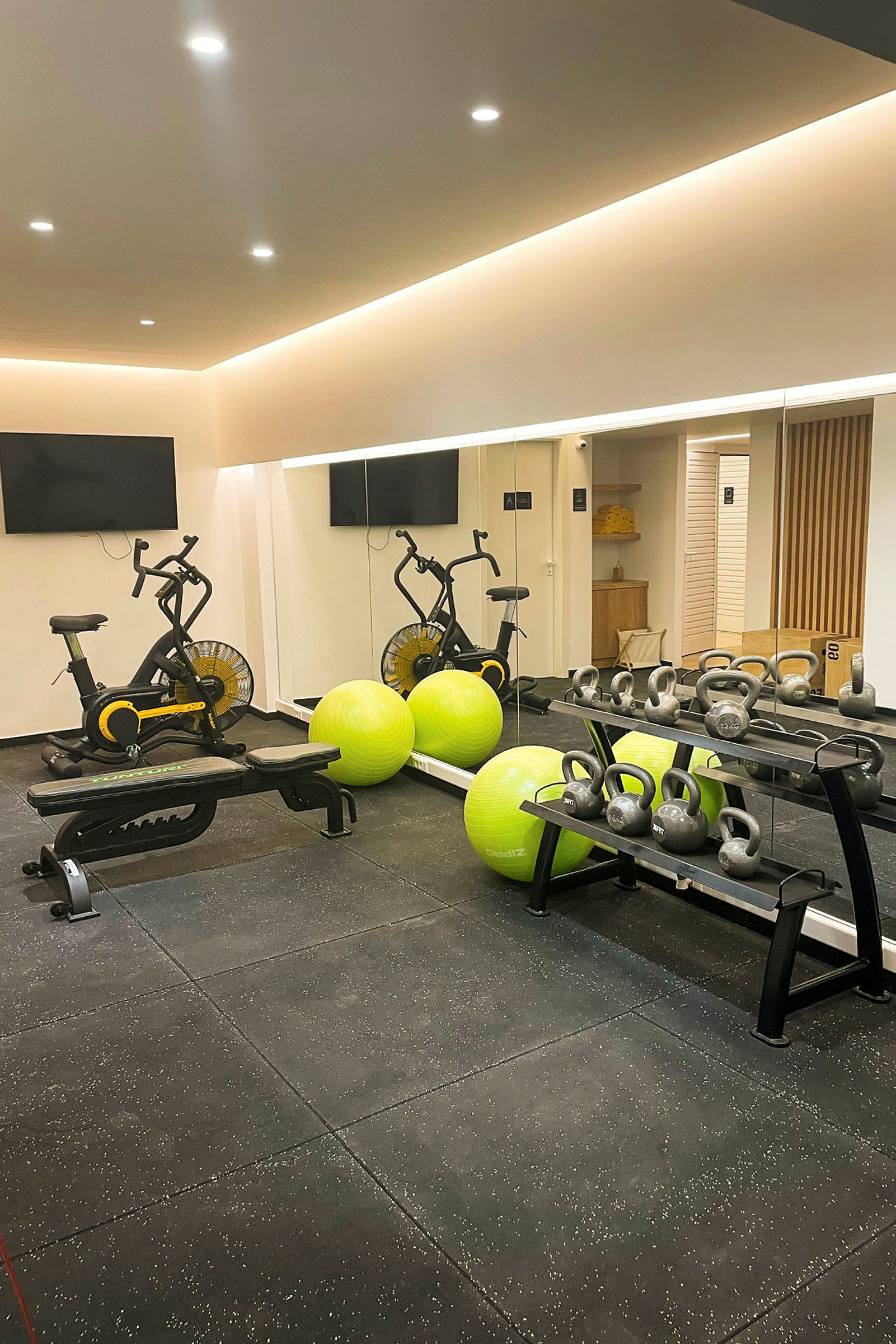 Ett gym med träningscyklar, gröna träningsbollar och kettlebells. (AI-genererad text)