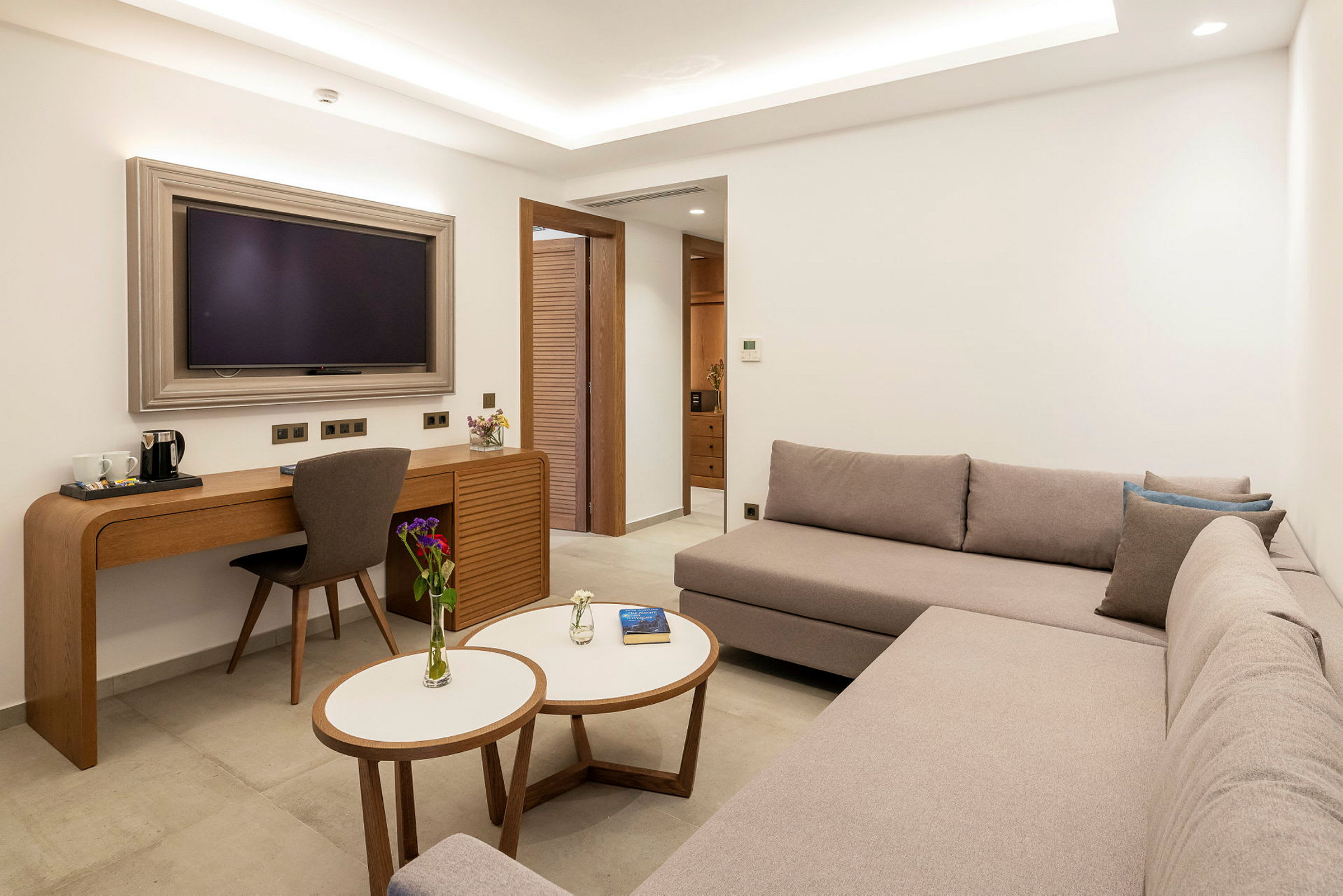 Ett modernt hotellrum med en soffa, ett skrivbord och en TV. (AI-genererad text)