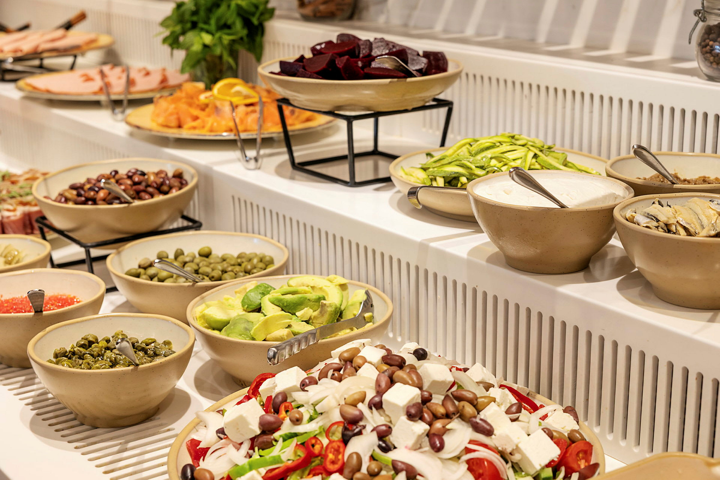 Ett buffébord fyllt med olika sallader och tillbehör. (AI-genererad text)