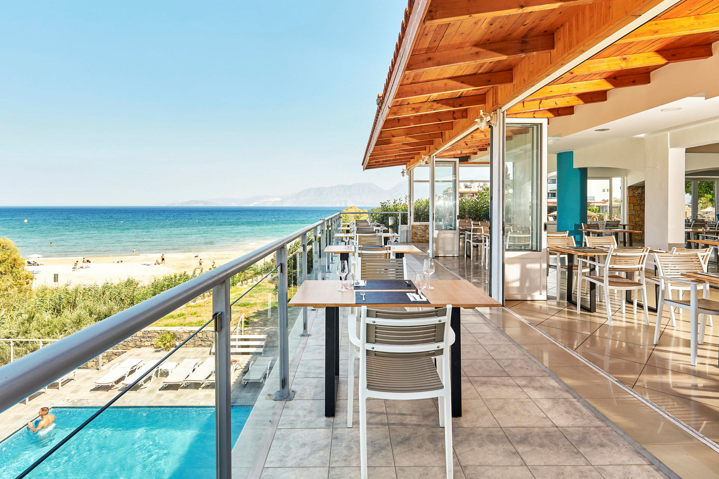 Uteservering vid en restaurang med utsikt över havet och stranden. (AI-genererad text)