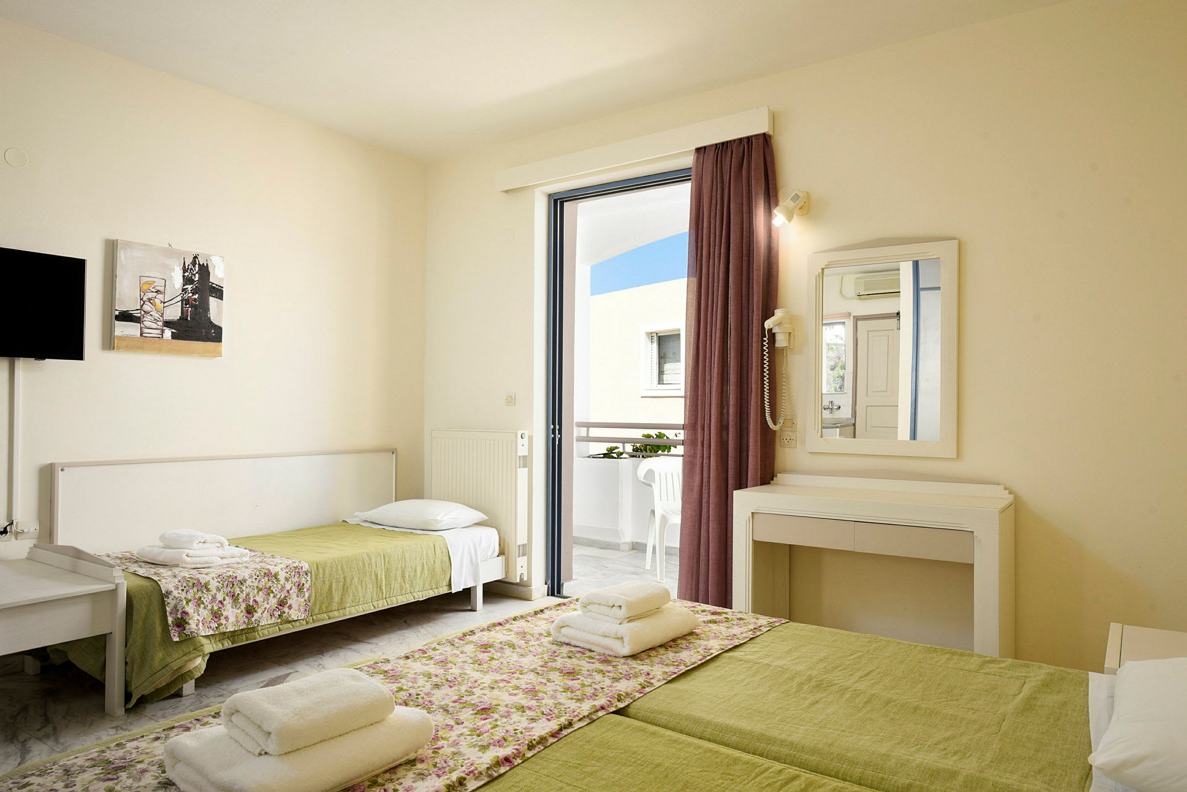 Ett hotellrum med två bäddar och en balkong. (AI-genererad text)