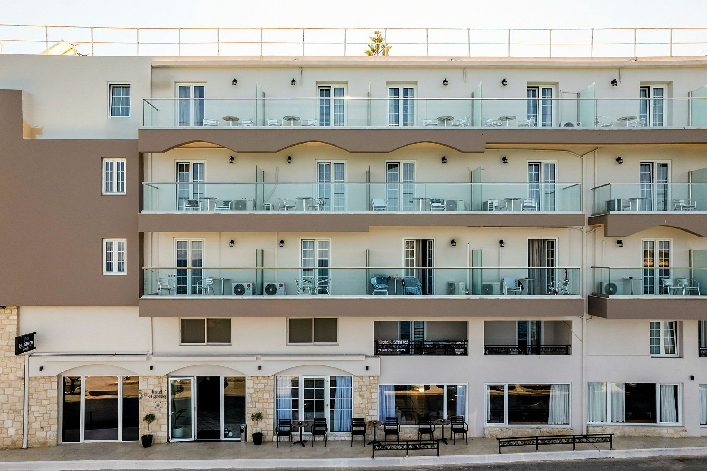 Hotellfasad med balkonger och entré på bottenvåningen. (AI-genererad text)