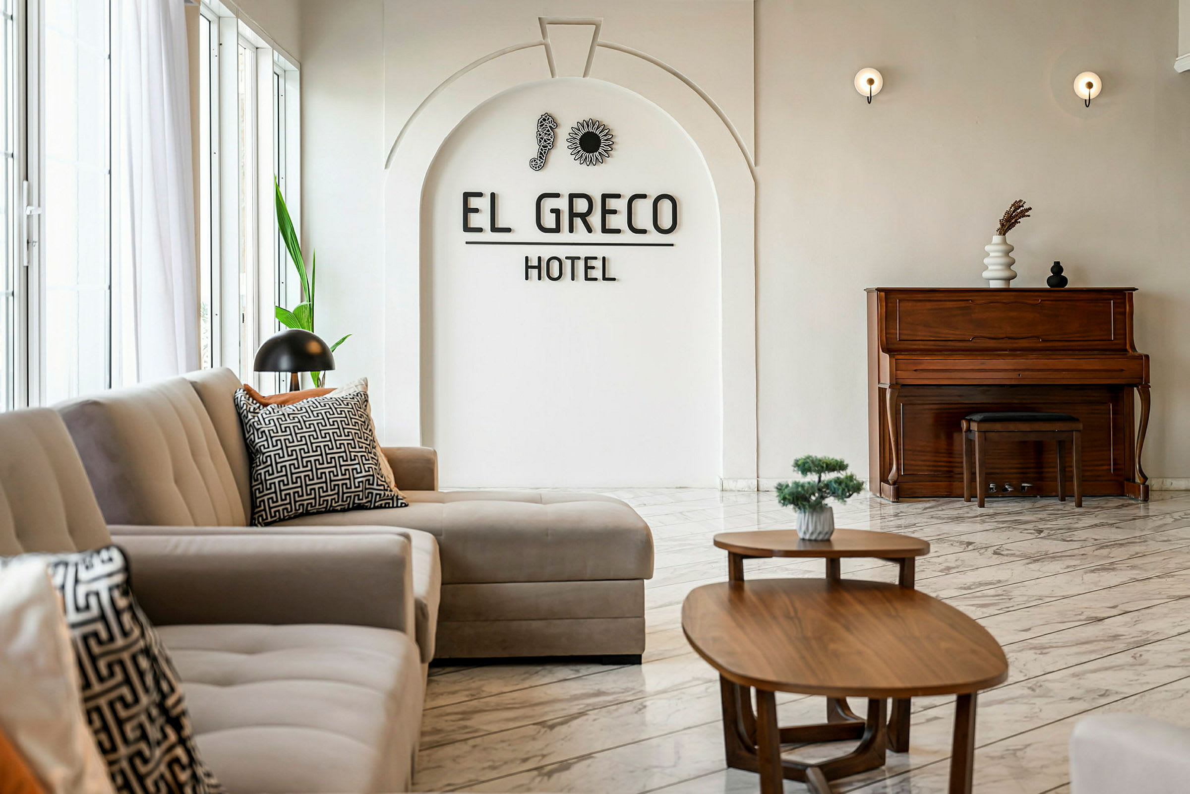 Interiör av ett hotell med soffor, bord och ett piano. (AI-genererad text)
