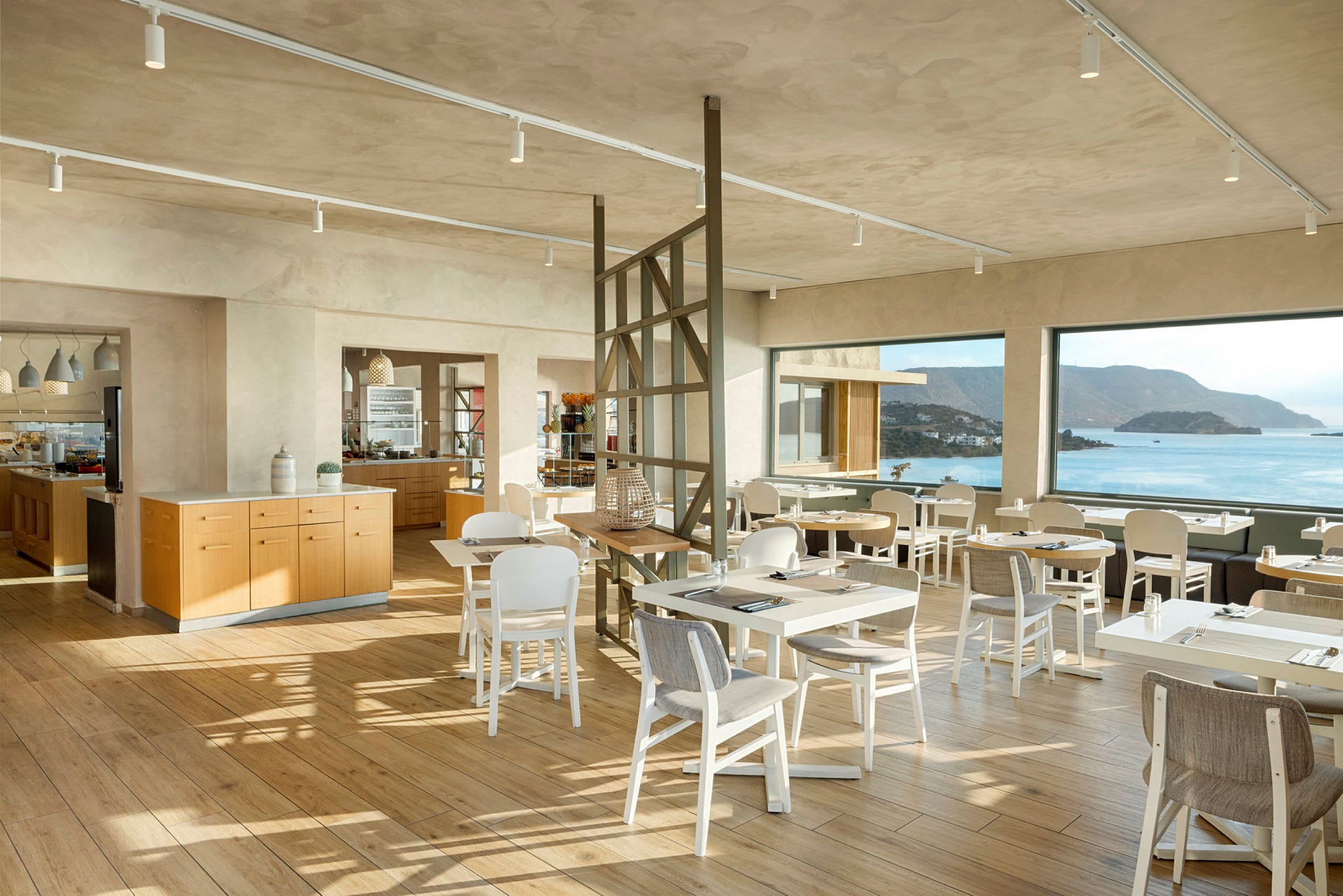 Modernt restaurangområde med stora panoramafönster och havsutsikt. (AI-genererad text)