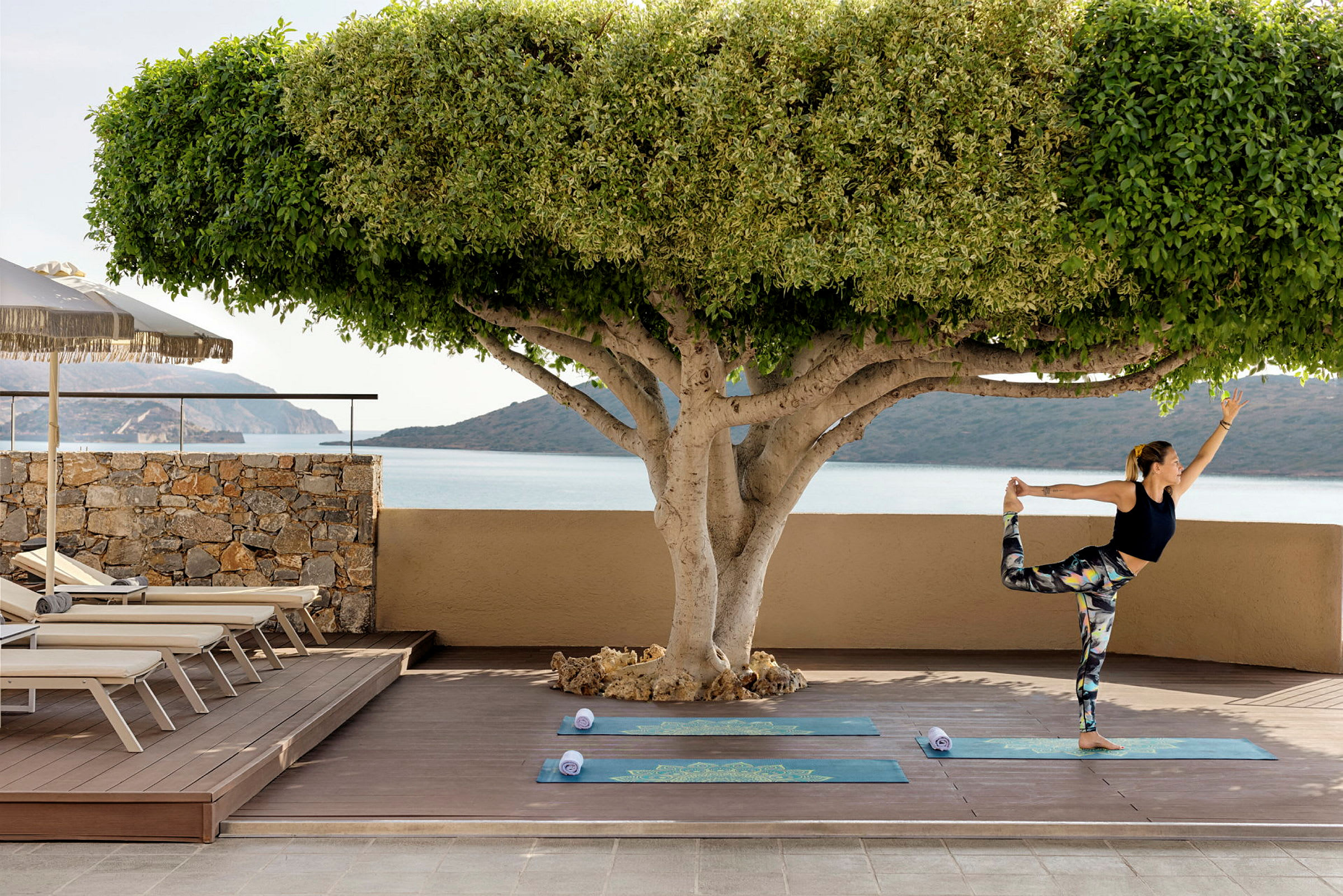 En person utför yoga på en uteplats med utsikt över havet. (AI-genererad text)