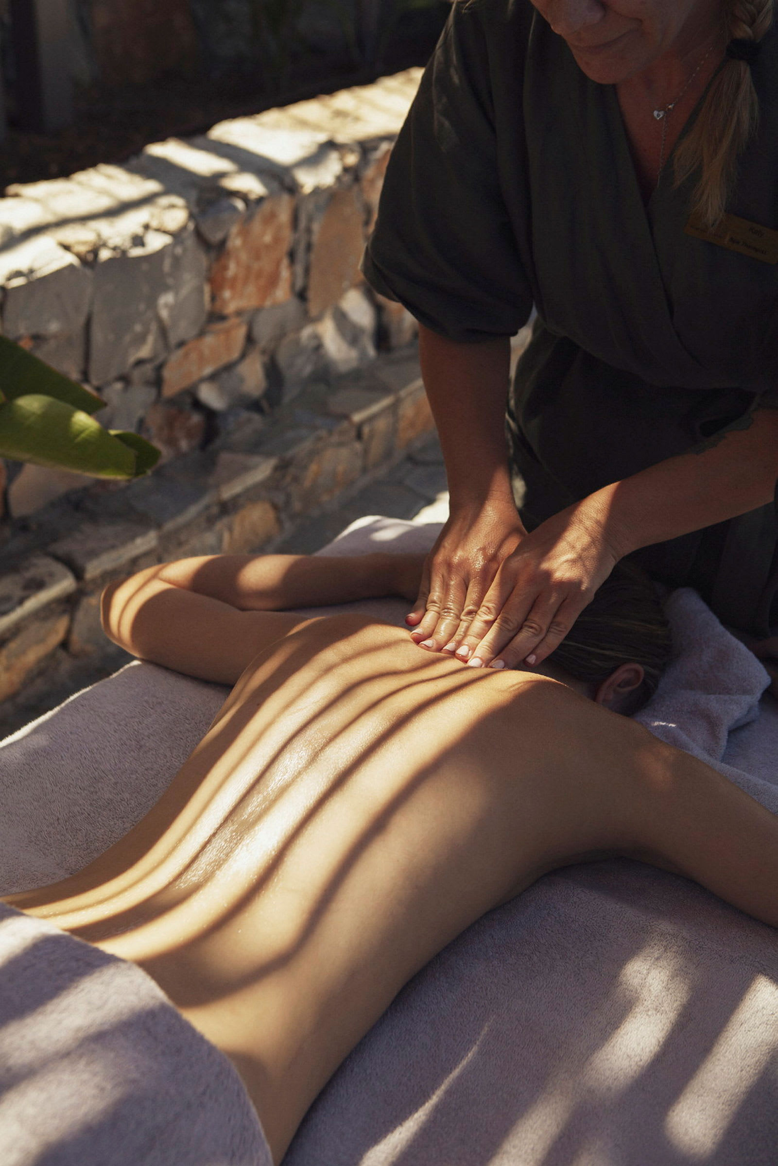 En person får ryggmassage utomhus. (AI-genererad text)