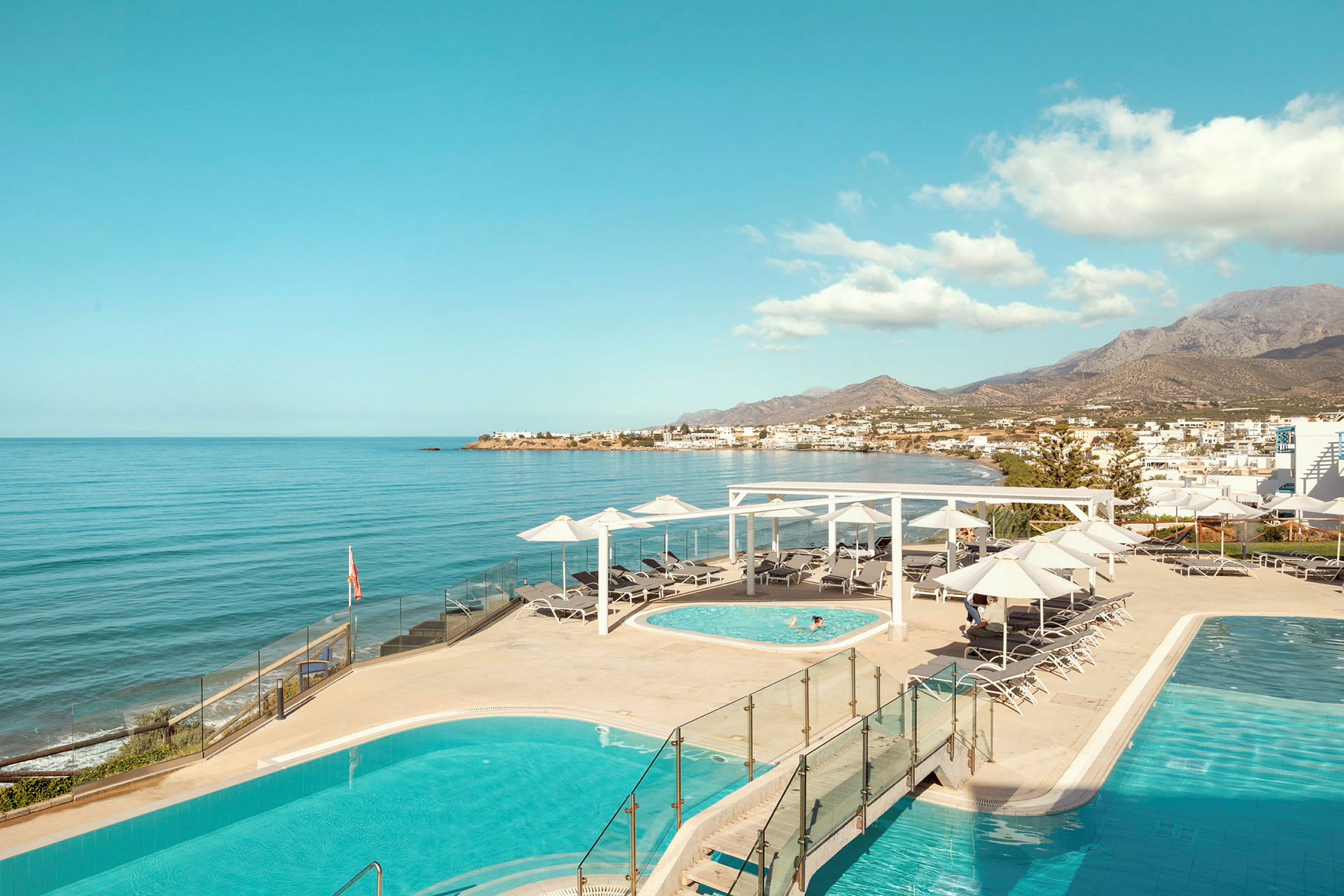 Hotellpoolområde med havsutsikt. (AI-genererad text)