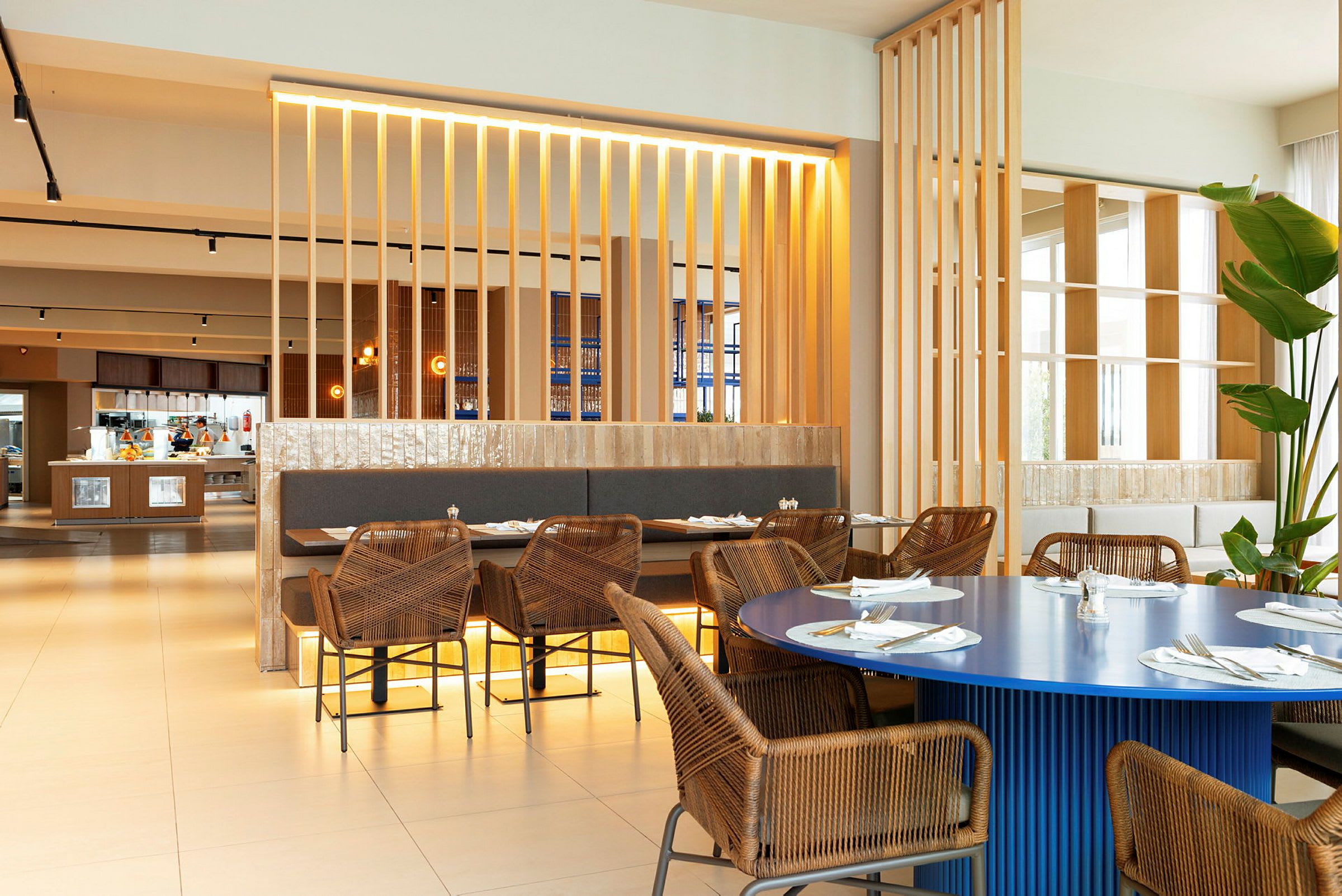 Interiör av en restaurang med rottingstolar och bord med dukar. (AI-genererad text)