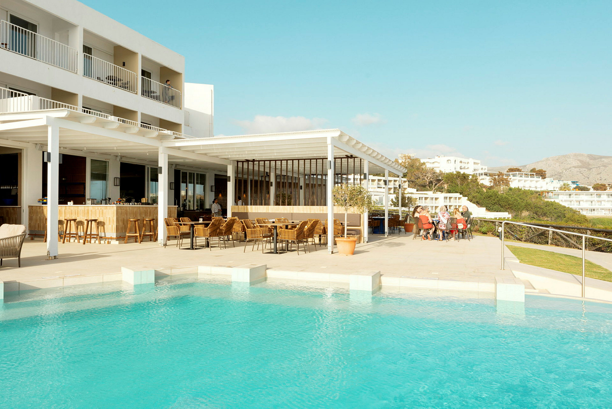 Hotellområde vid pool med uteservering. (AI-genererad text)