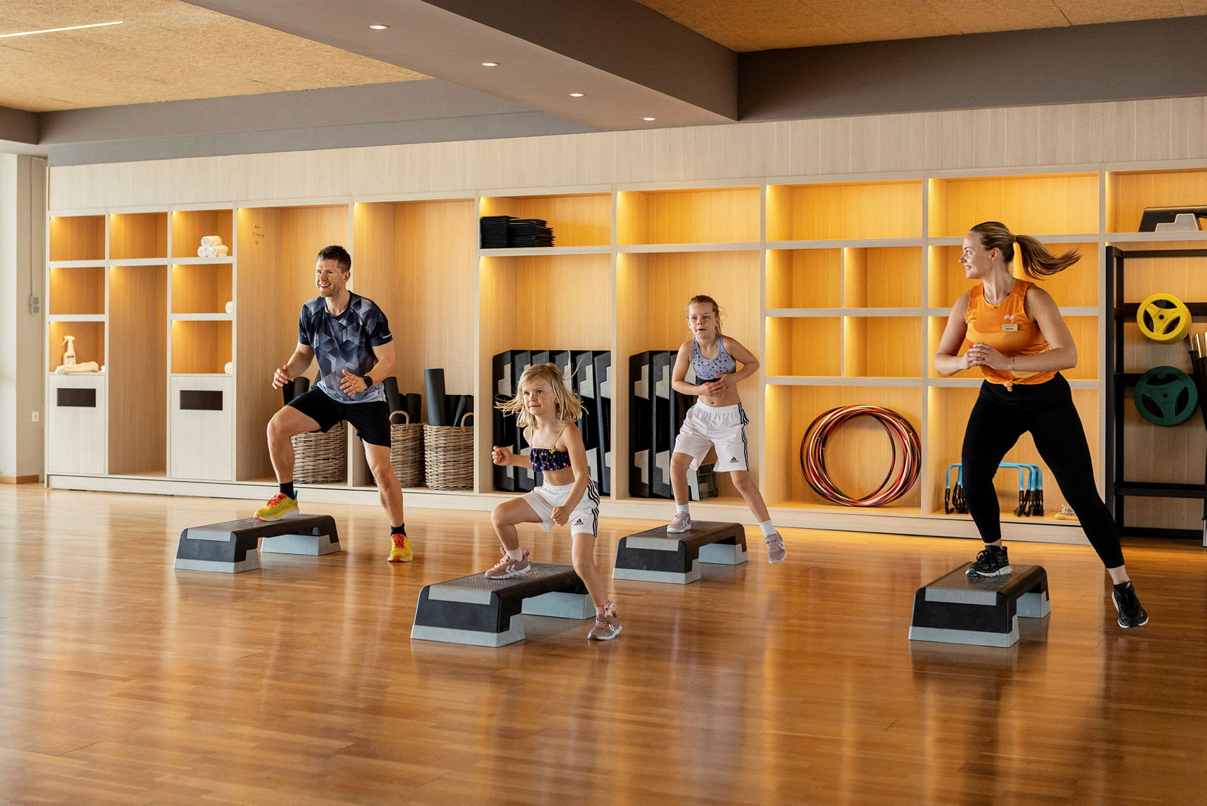 Fyra personer tränar med stegplattor i ett gym. (AI-genererad text)