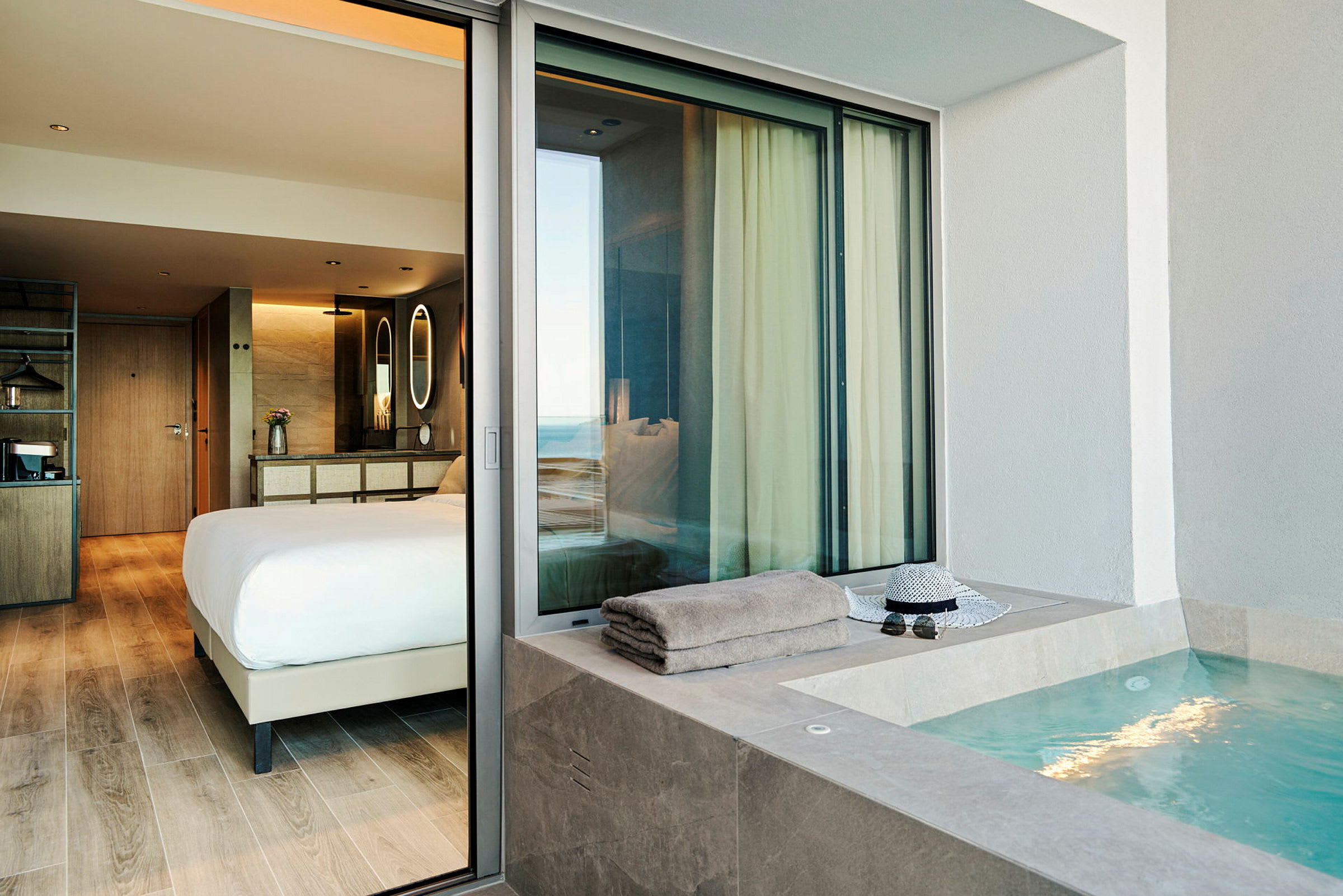 En hotellsvit med ett sovrum och en jacuzzi utomhus. (AI-genererad text)