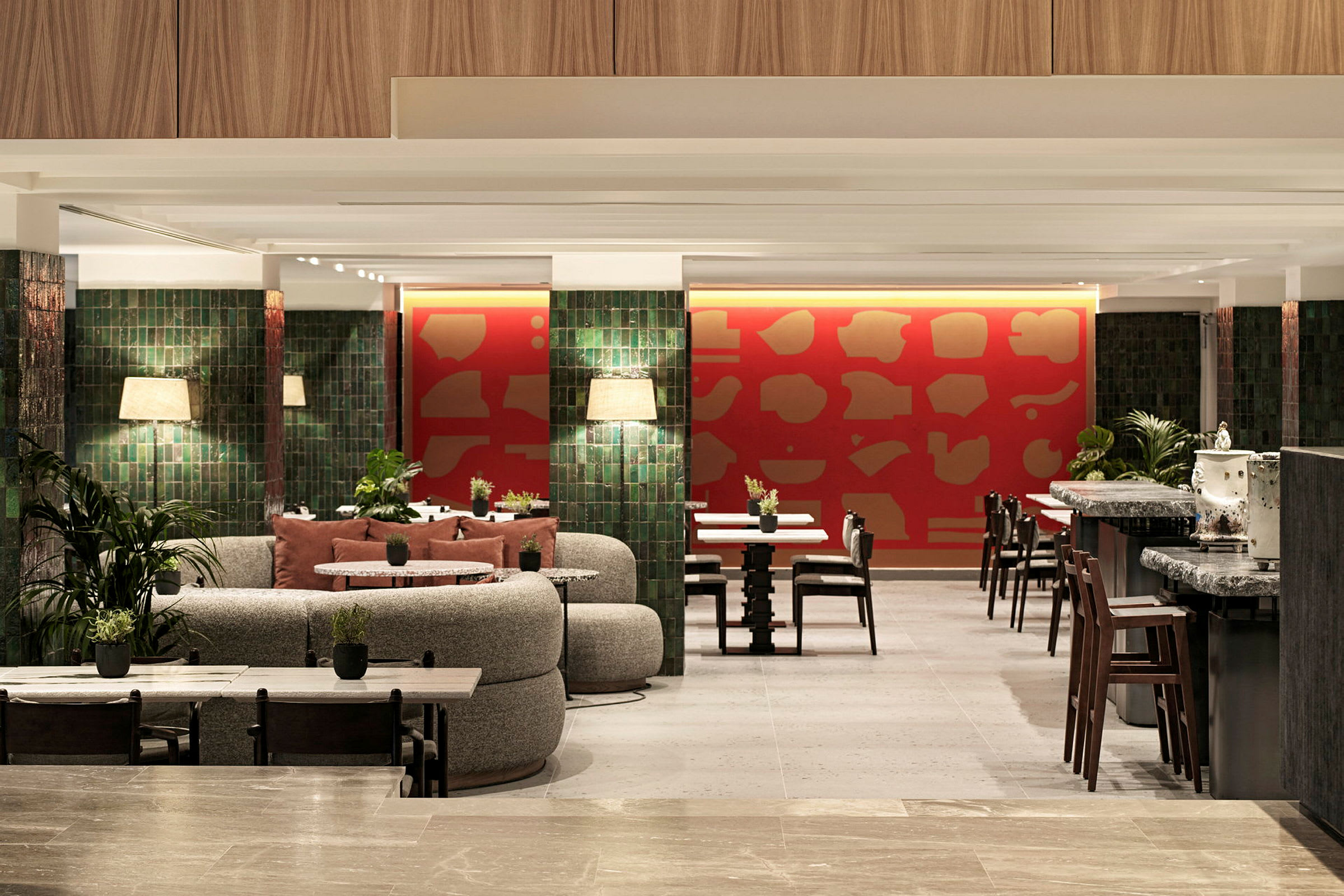 Modern restaurang med dekorativa röda väggar och gröna pelare. (AI-genererad text)