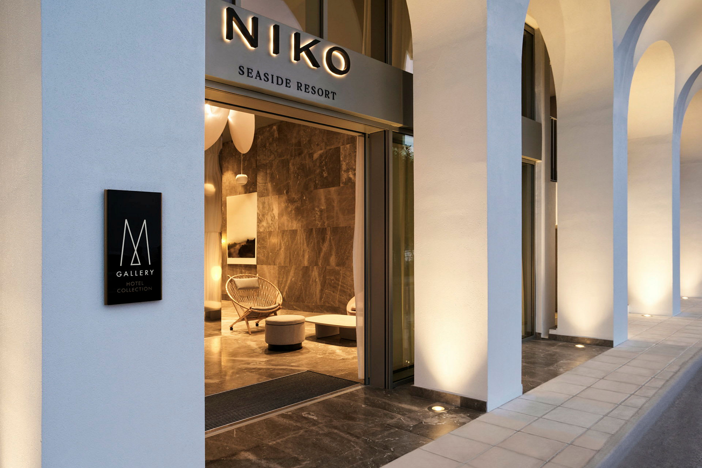 Entrén till Niko Seaside Resort, med synliga skyltar och modern inredning. (AI-genererad text)