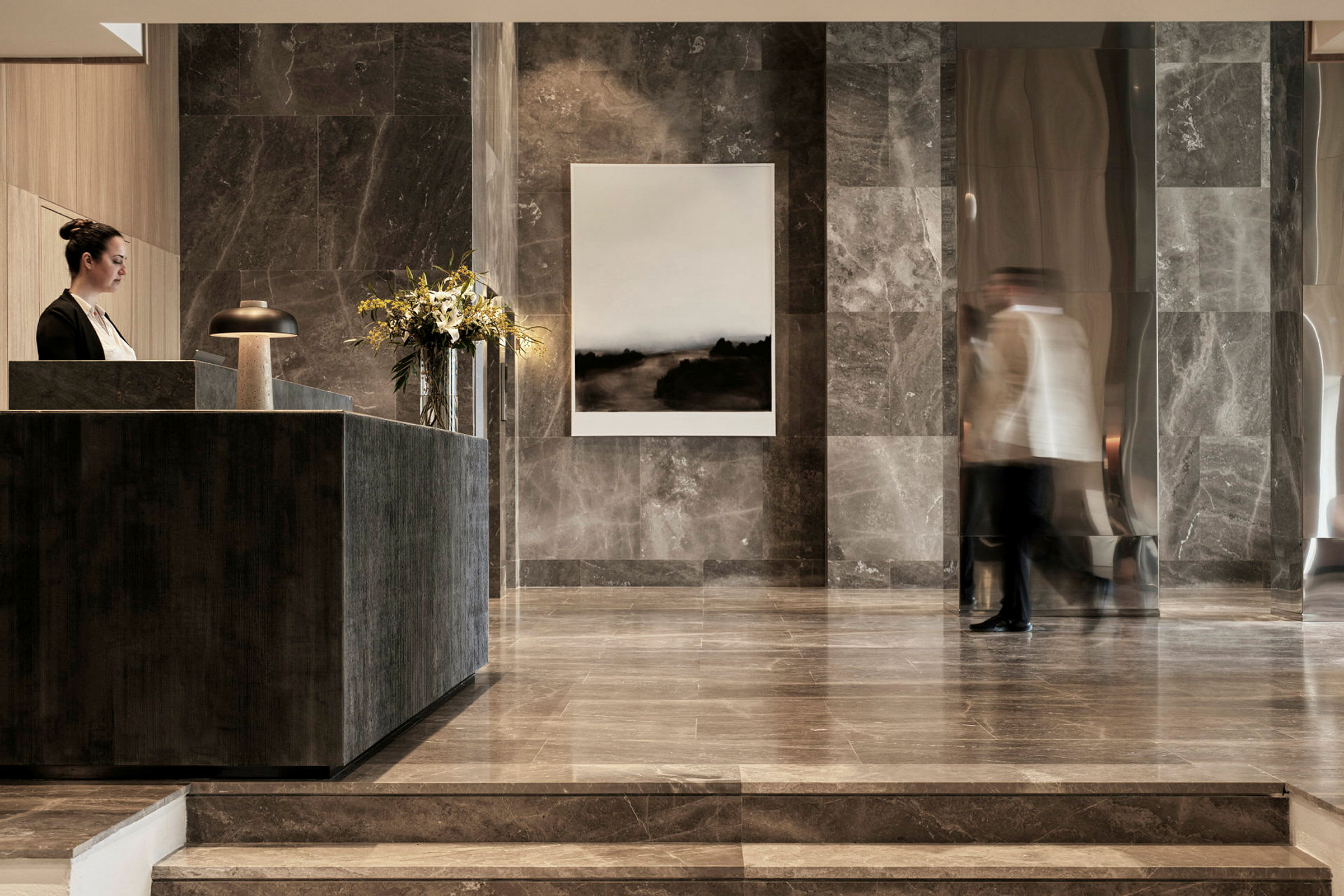 Hotellobbyn med modern marmorinredning och ett receptionsområde. (AI-genererad text)