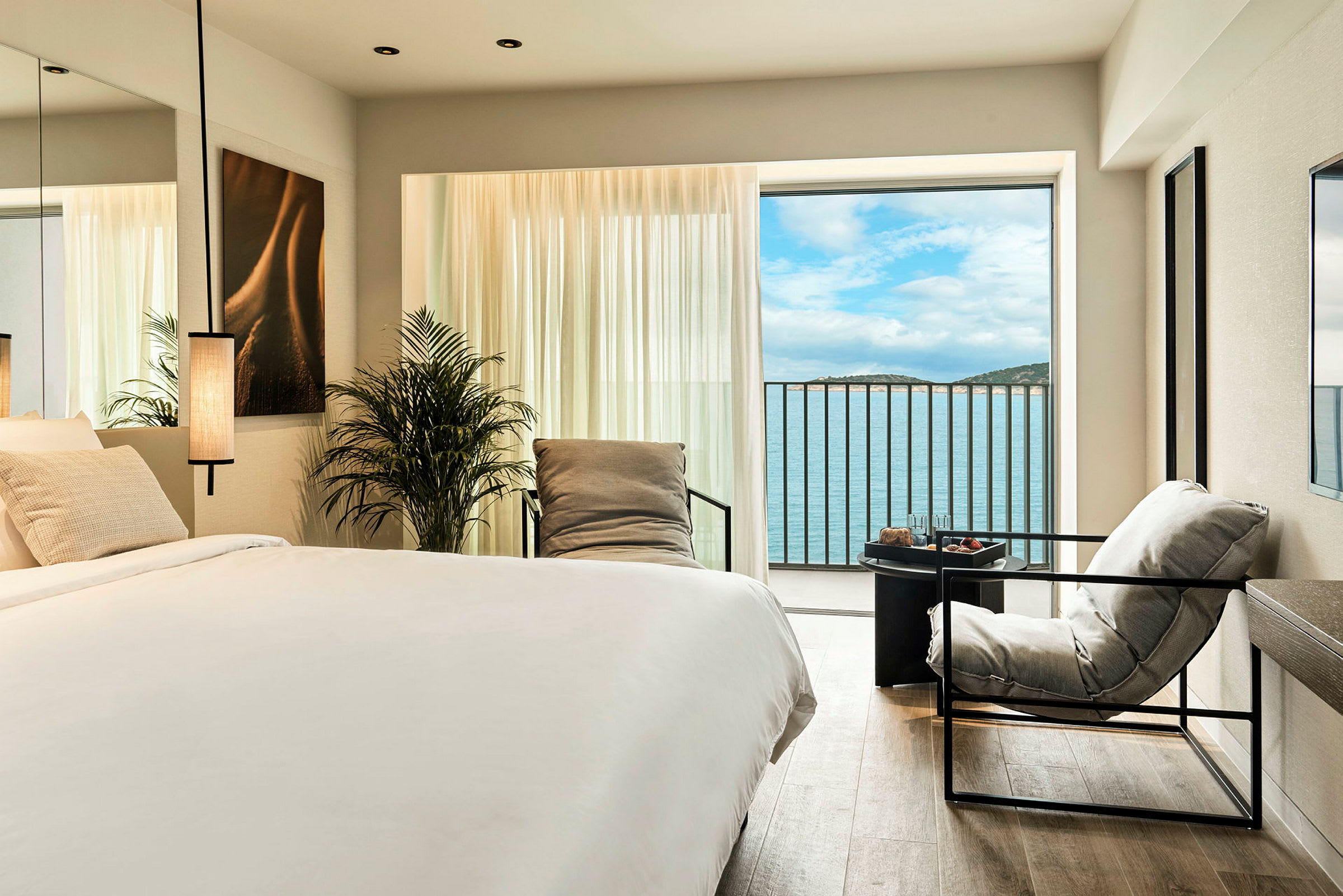 Elegant hotellrum med havsutsikt genom stort fönster. (AI-genererad text)