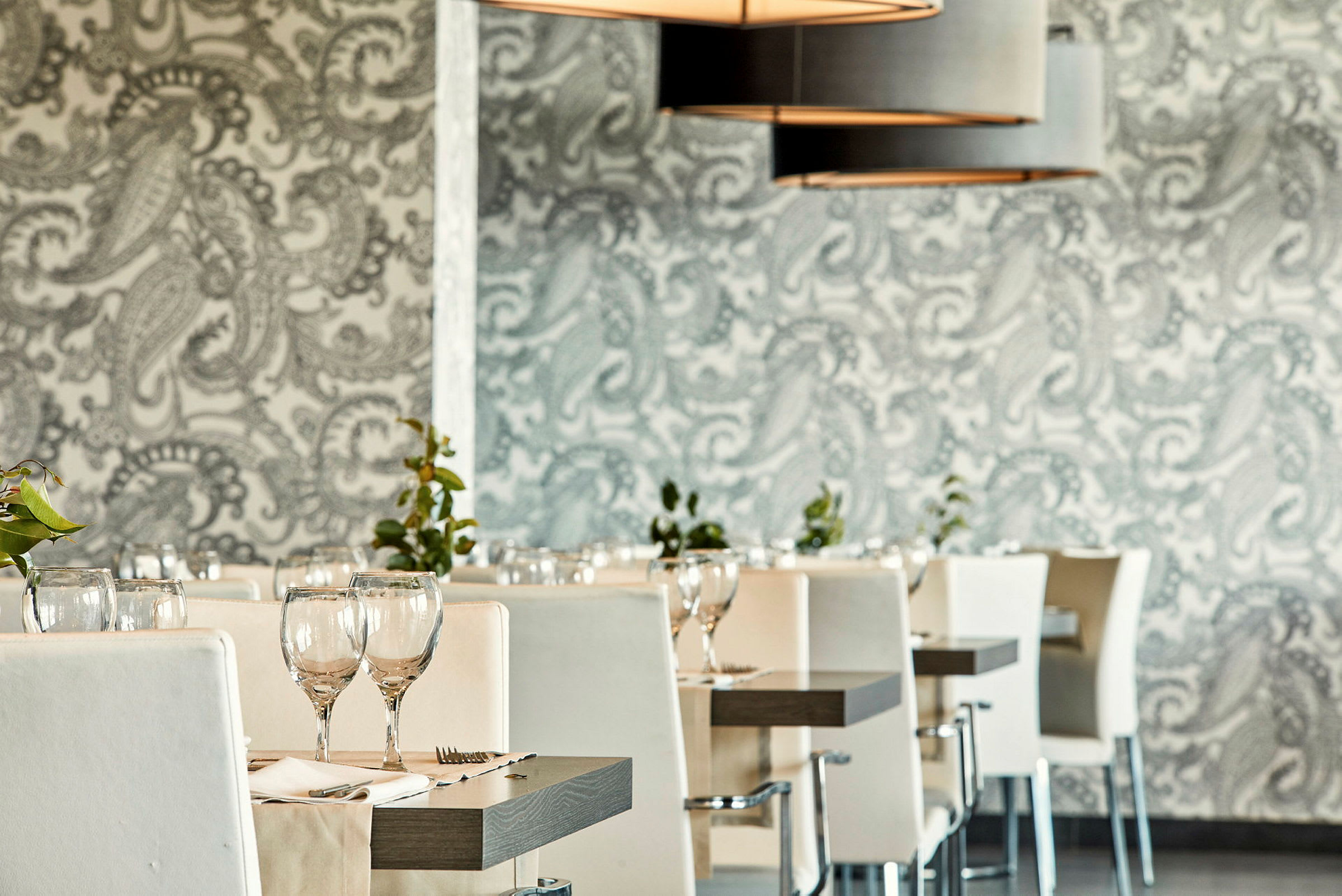 Restaurang med vita stolar och dukade bord. (AI-genererad text)