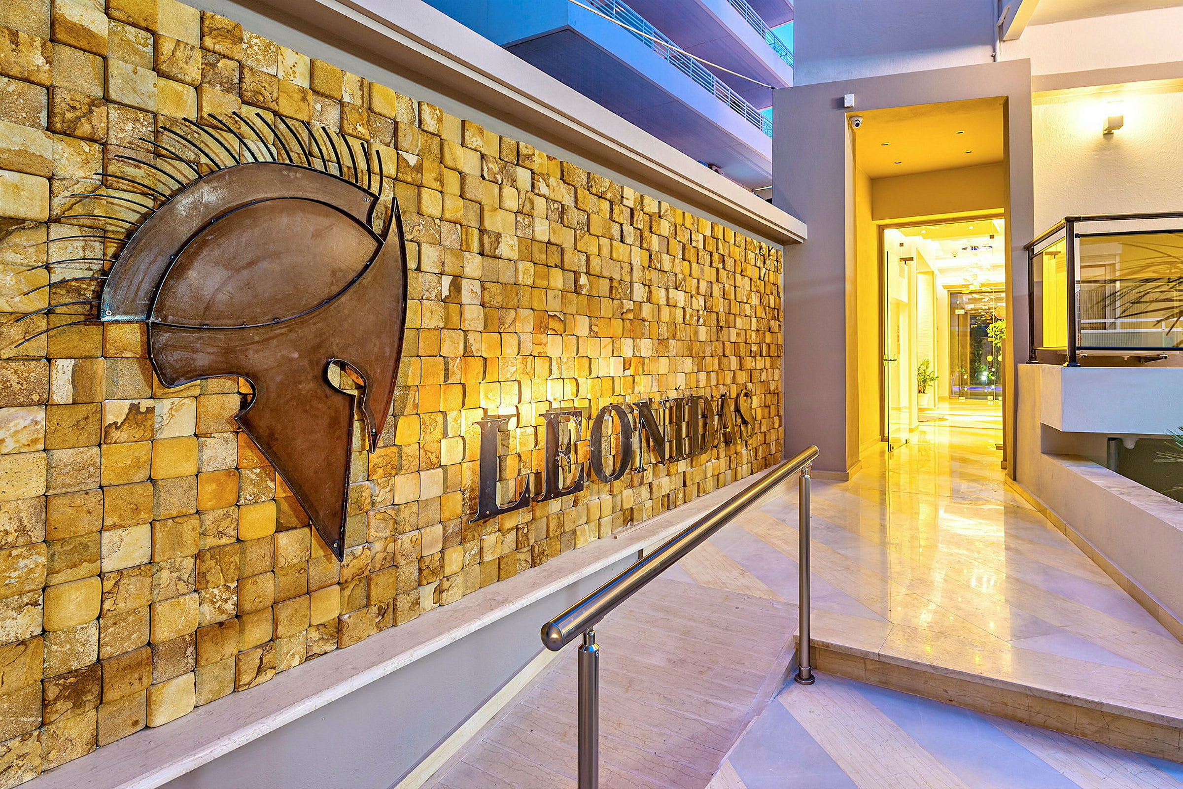 Ingång till Leonidas hotell med en väggdekoration av en hjälm. (AI-genererad text)