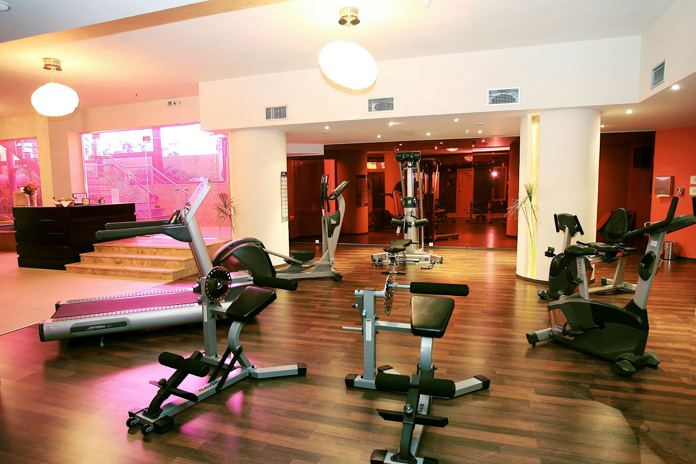Gym med träningsmaskiner och träpanelgolv. (AI-genererad text)