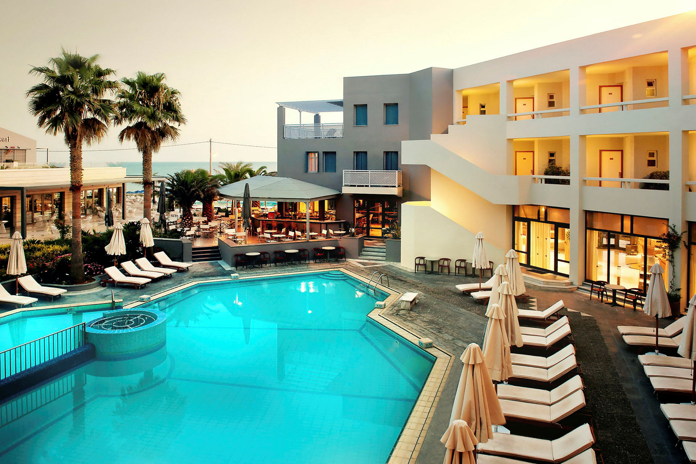 Hotell med pool, solstolar och restaurangområde. (AI-genererad text)