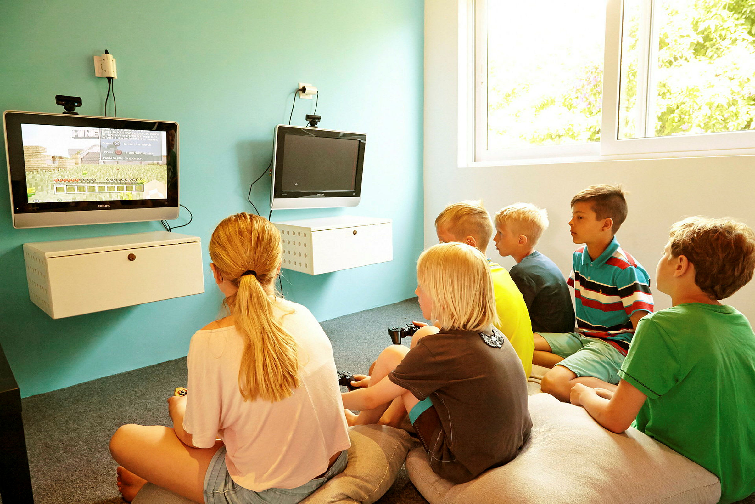 Barn som spelar tv-spel i ett ljust rum. (AI-genererad text)