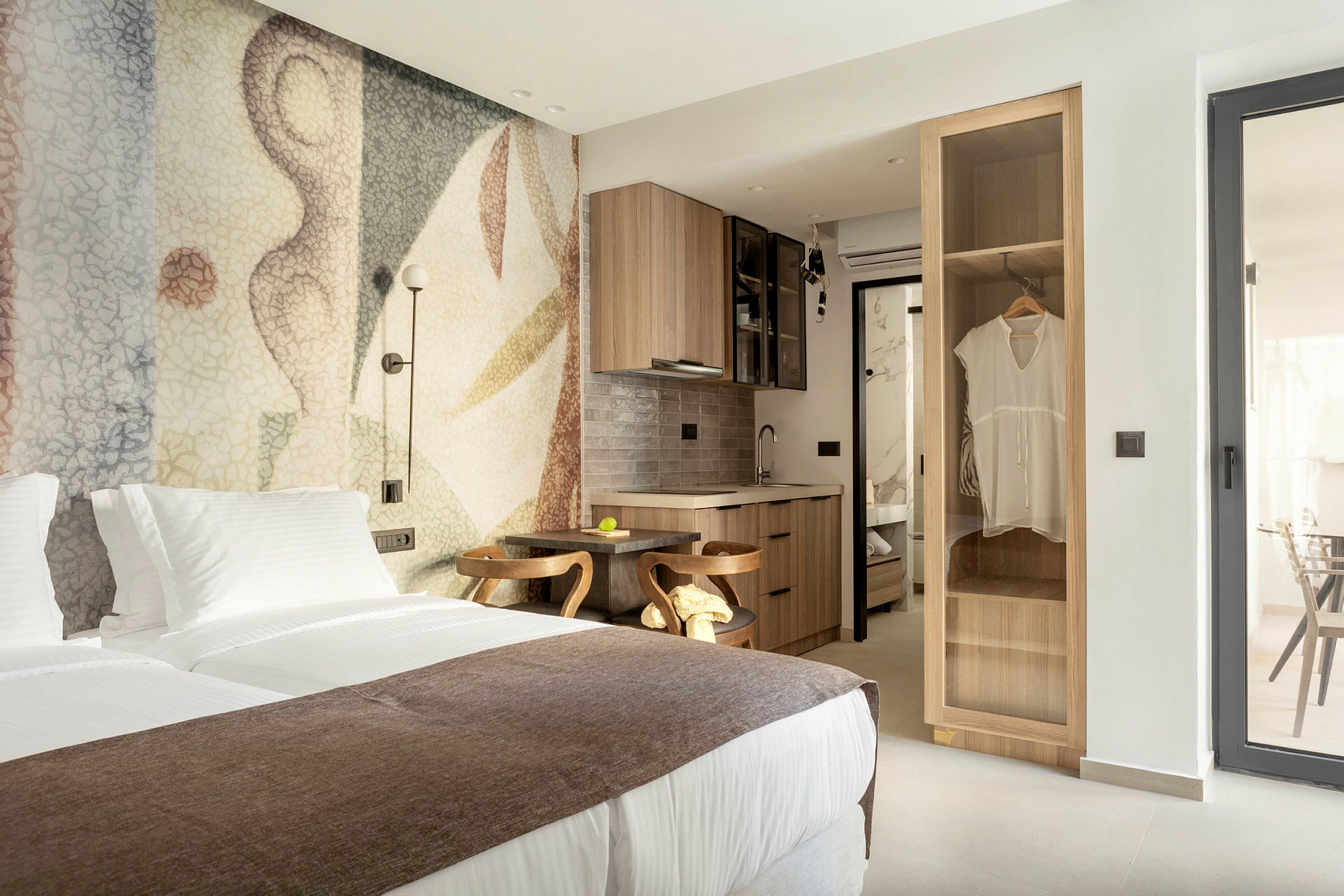 Modernt hotellrum med dubbelsäng, mysig inredning och en liten köksdel. (AI-genererad text)