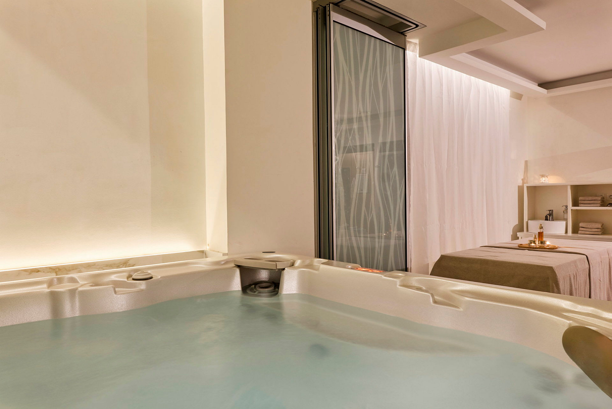 Ett spa-rum med en jacuzzi och en behandlingsbänk. (AI-genererad text)