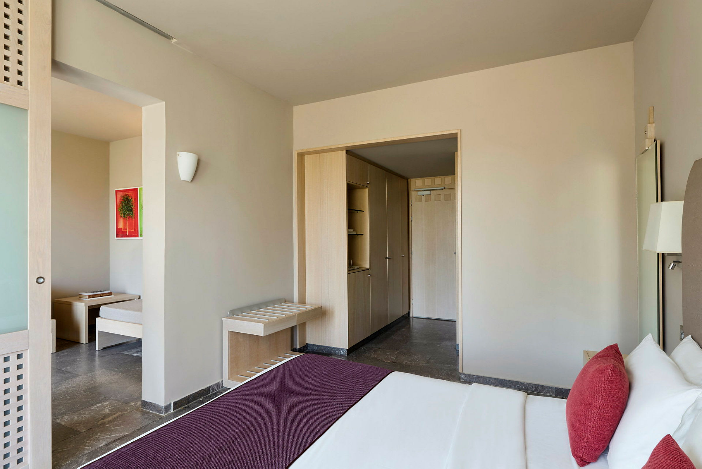 Ett hotellrum med en säng, en garderob och en sittdel. (AI-genererad text)