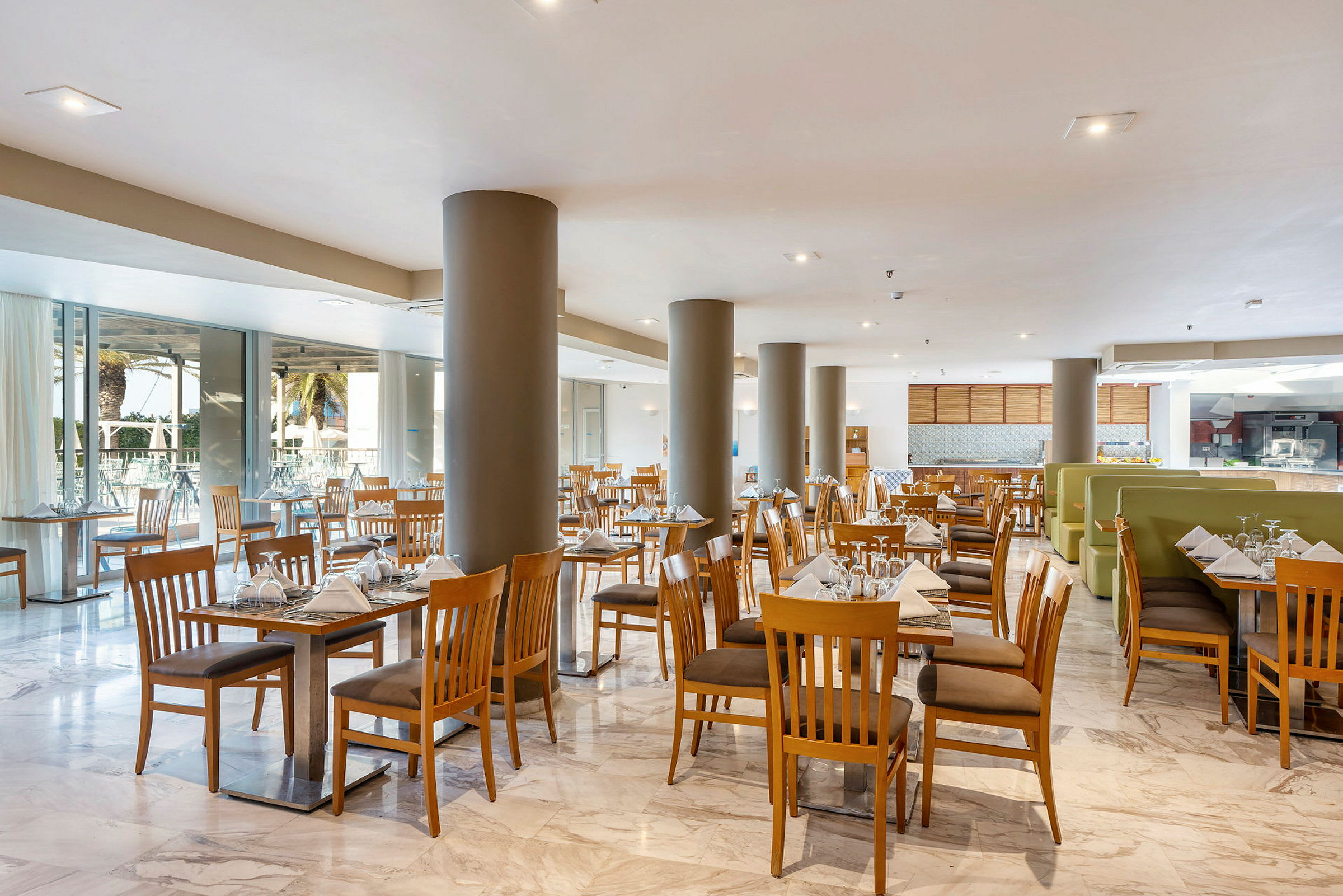 En ljus restaurang med trästolar och dukade bord. (AI-genererad text)
