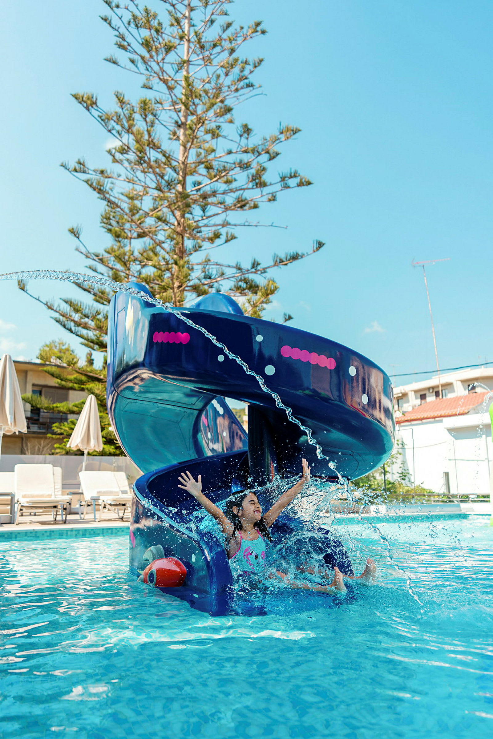 En blå vattenrutschbana med vatten som skvätter i en pool. (AI-genererad text)