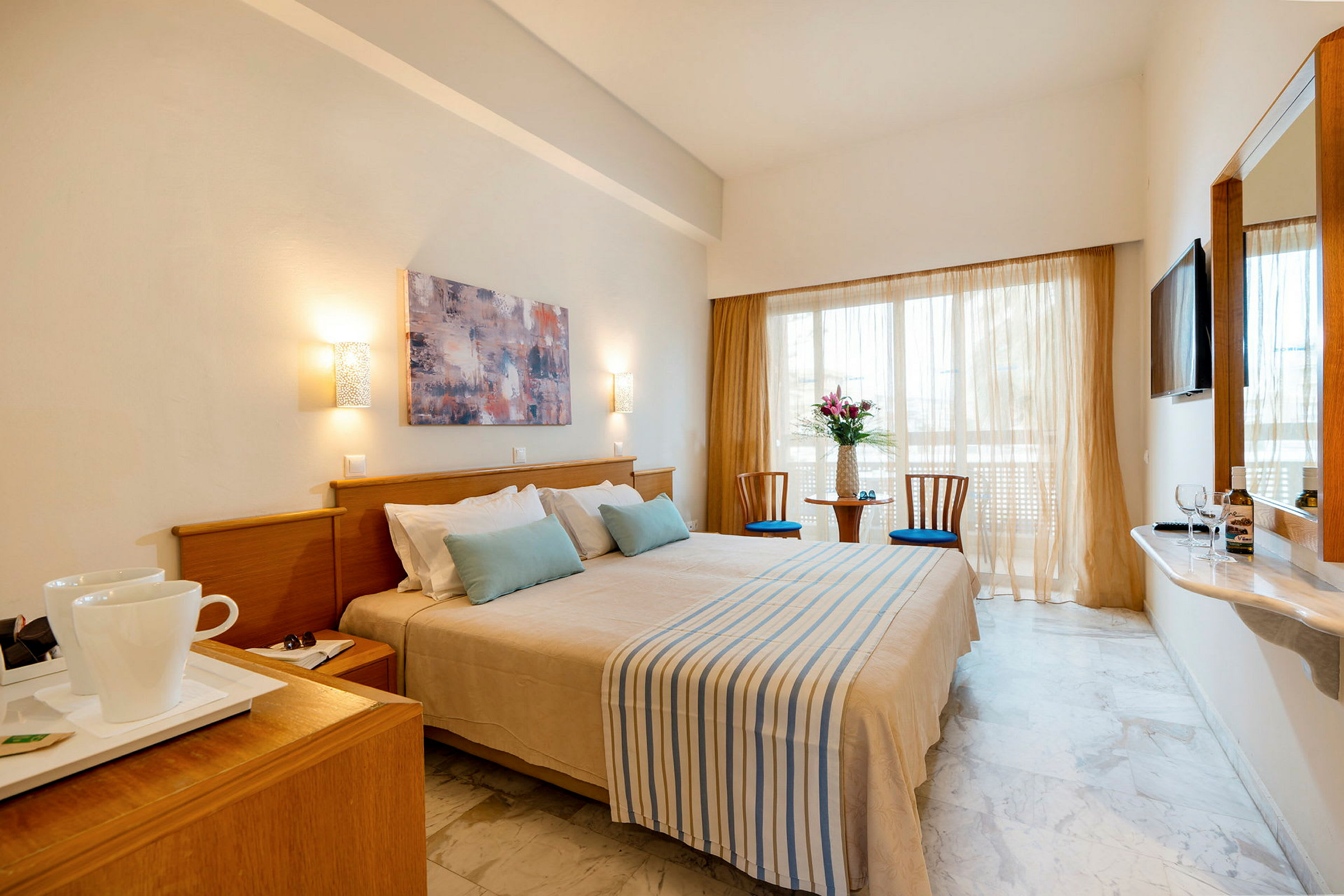 Hotellrum med en dubbelsäng, två stolar och ett bord vid fönstret. (AI-genererad text)