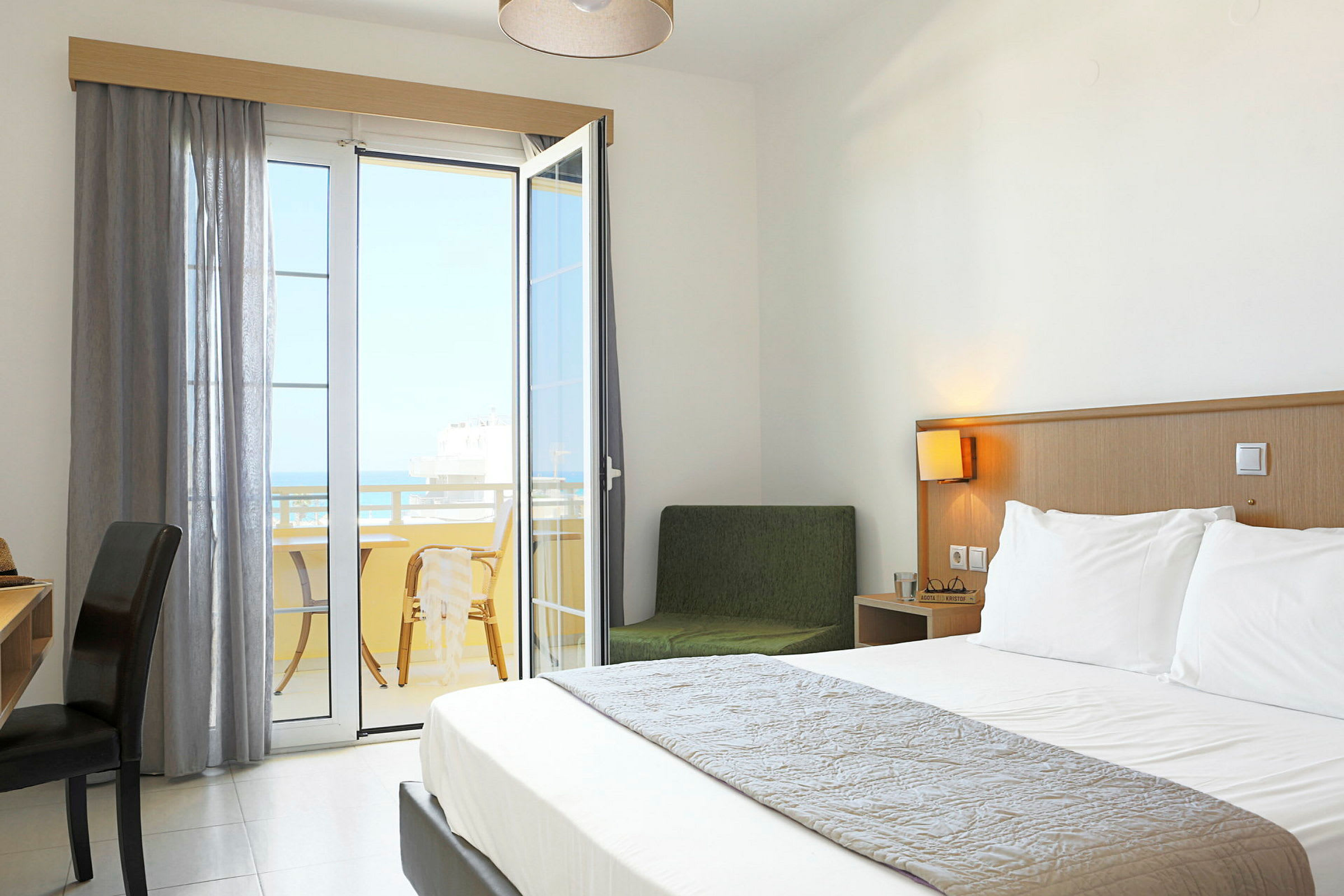Ett hotellrum med en dubbelsäng och en balkong med utsikt. (AI-genererad text)