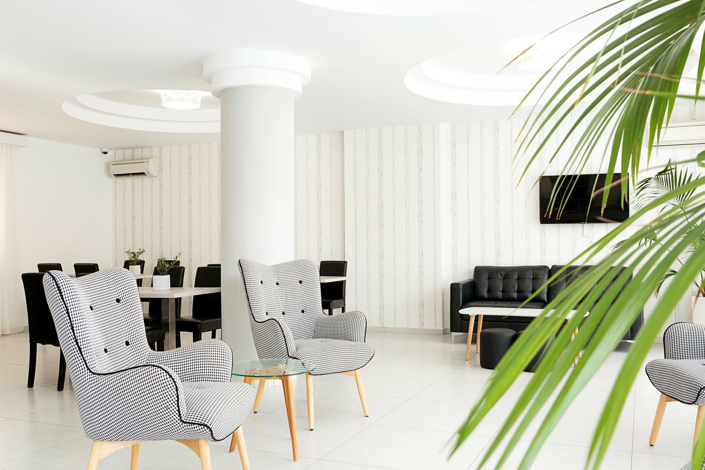 Modern hotelllounge med fåtöljer, soffor och växtdekorationer. (AI-genererad text)