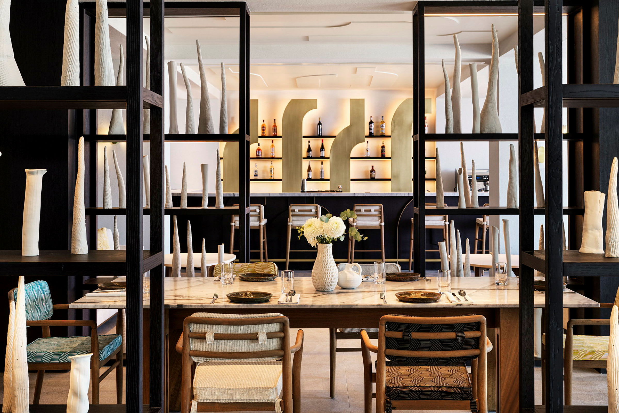 Inredning av en restaurang med dukade bord, designerstolar och konstföremål. (AI-genererad text)