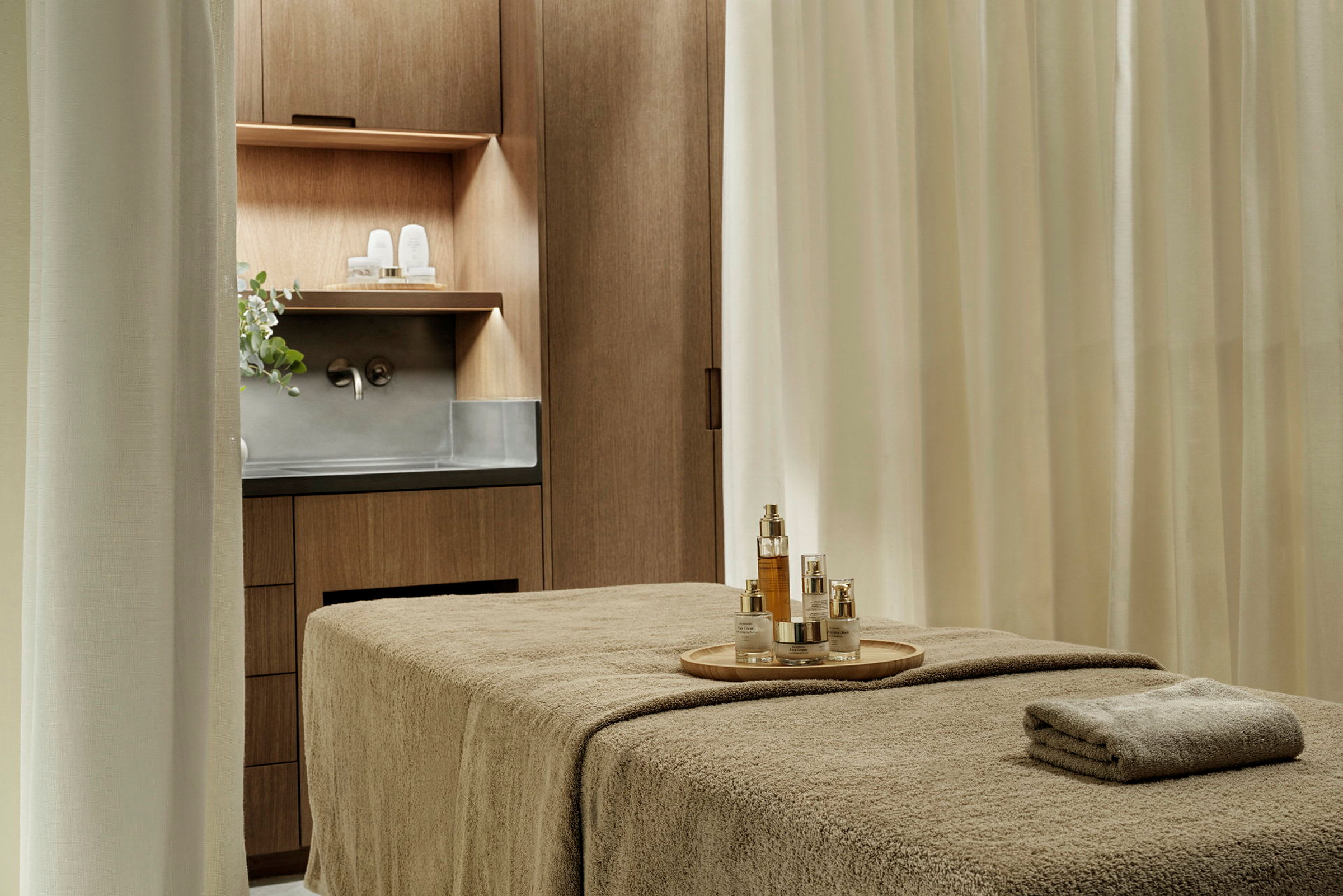 Ett rum med massagebänk, skåp och handfat. (AI-genererad text)
