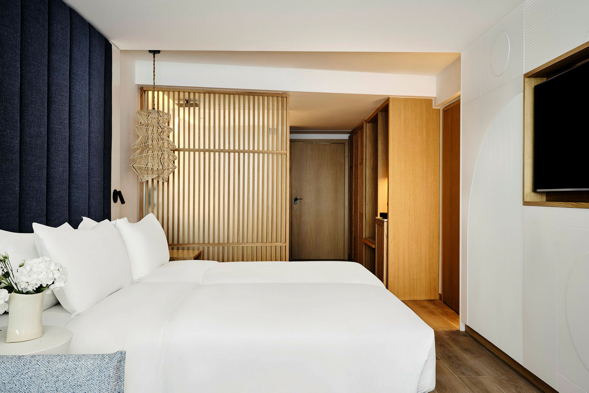 Bild av ett modernt hotellrum med en säng med vita lakan och trädetaljer. (AI-genererad text)