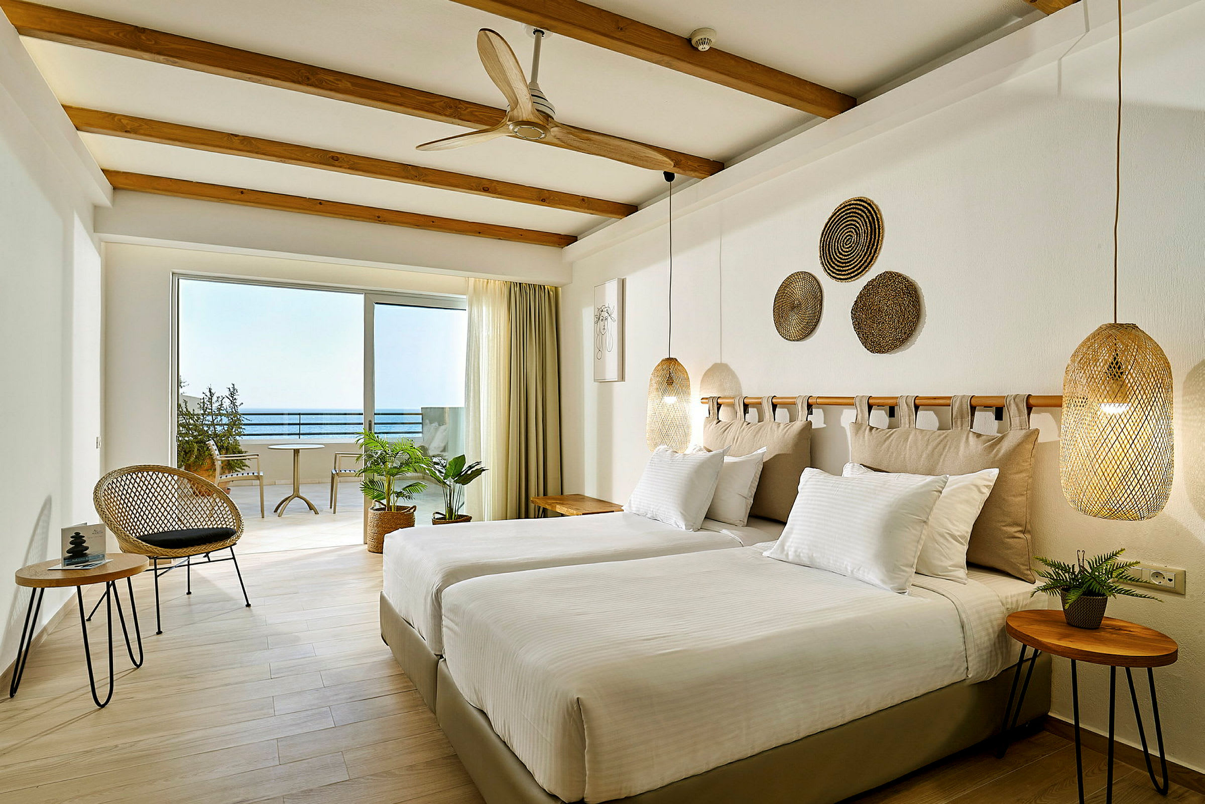 Ljus och modern hotellrum med två enkelsängar och havsutsikt. (AI-genererad text)