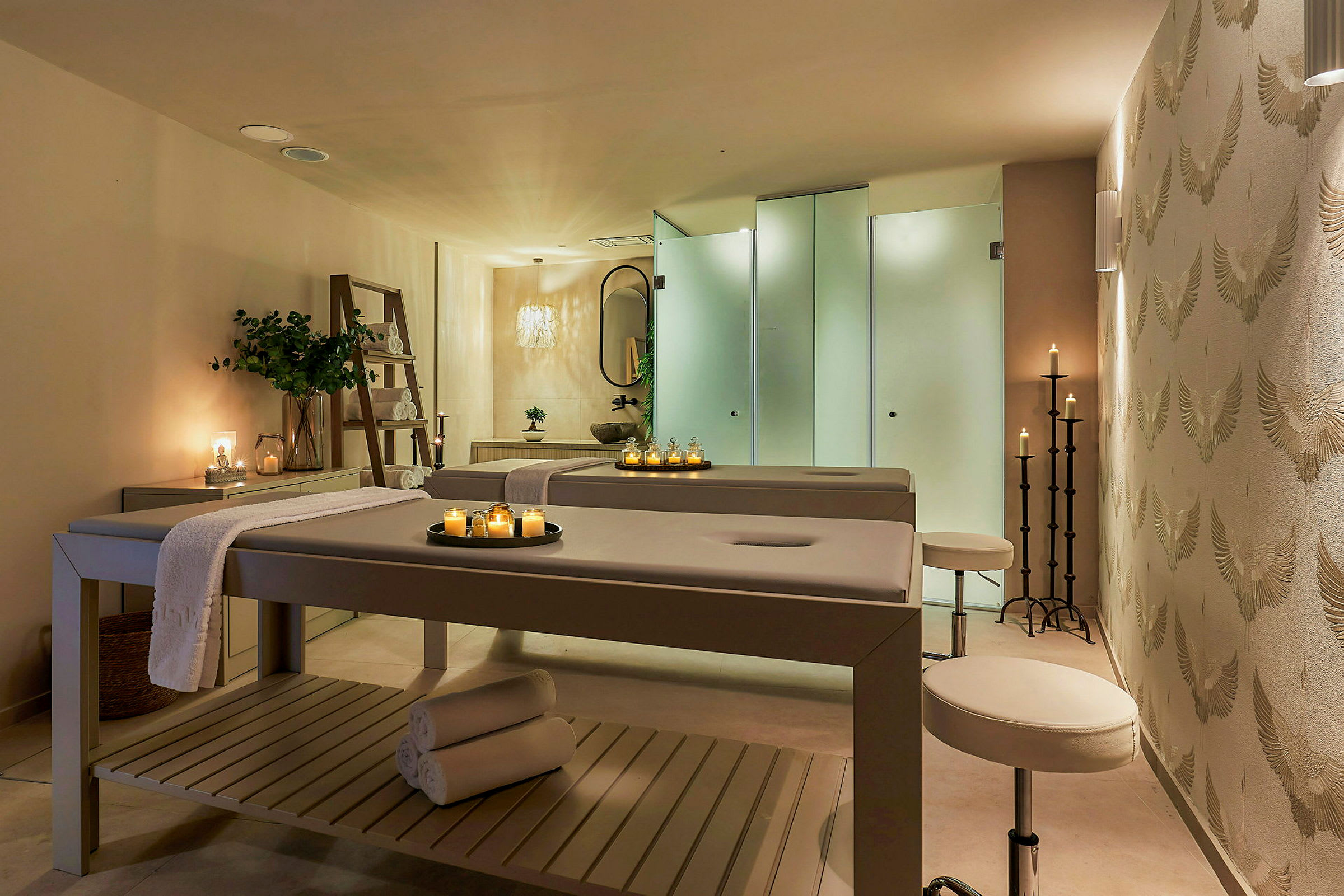 Ett spa-rum med behandlingsbänkar, levande ljus och en lugn atmosfär. (AI-genererad text)
