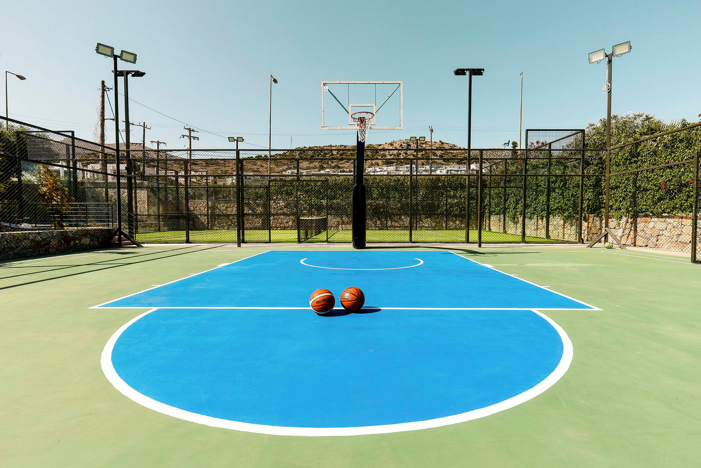 En basketplan med blå markeringar och två basketbollar placerade i mitten. (AI-genererad text)