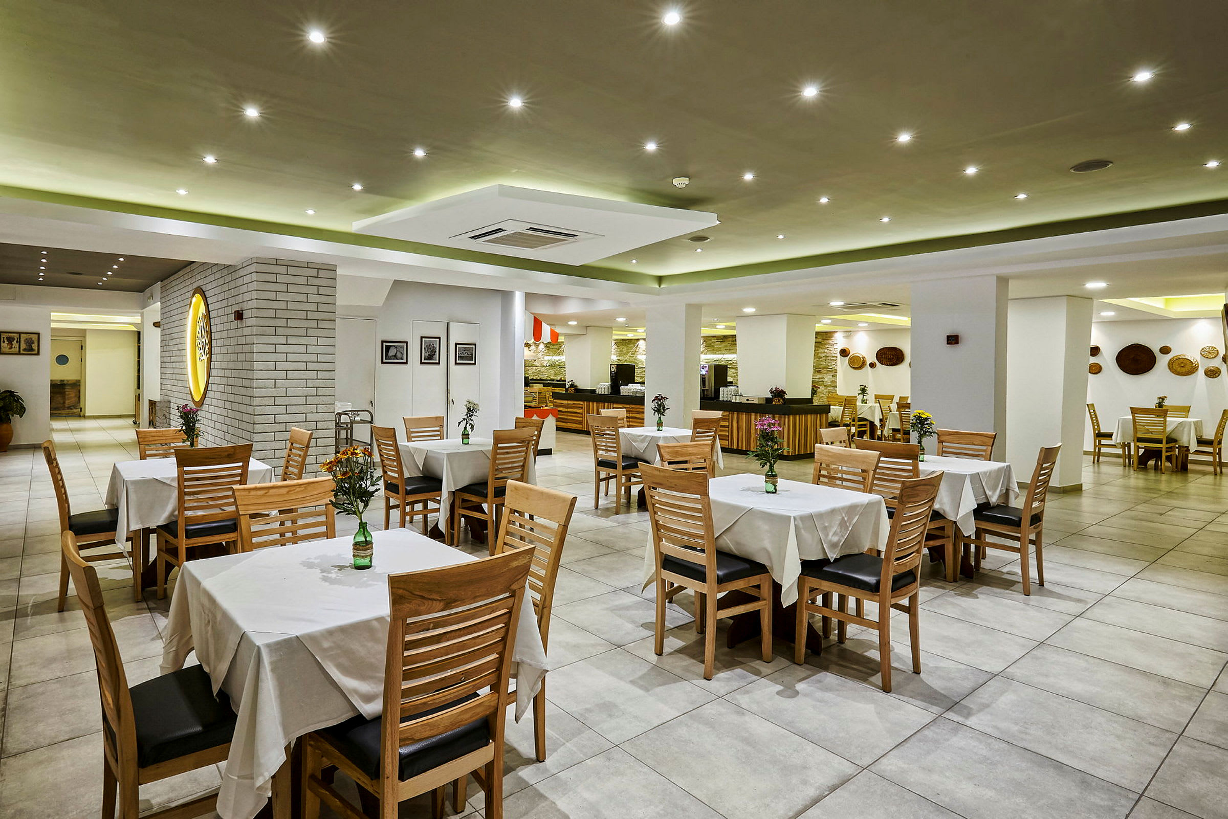Restaurangmiljö med bord och stolar, dekorerade med vaser och blommor. (AI-genererad text)