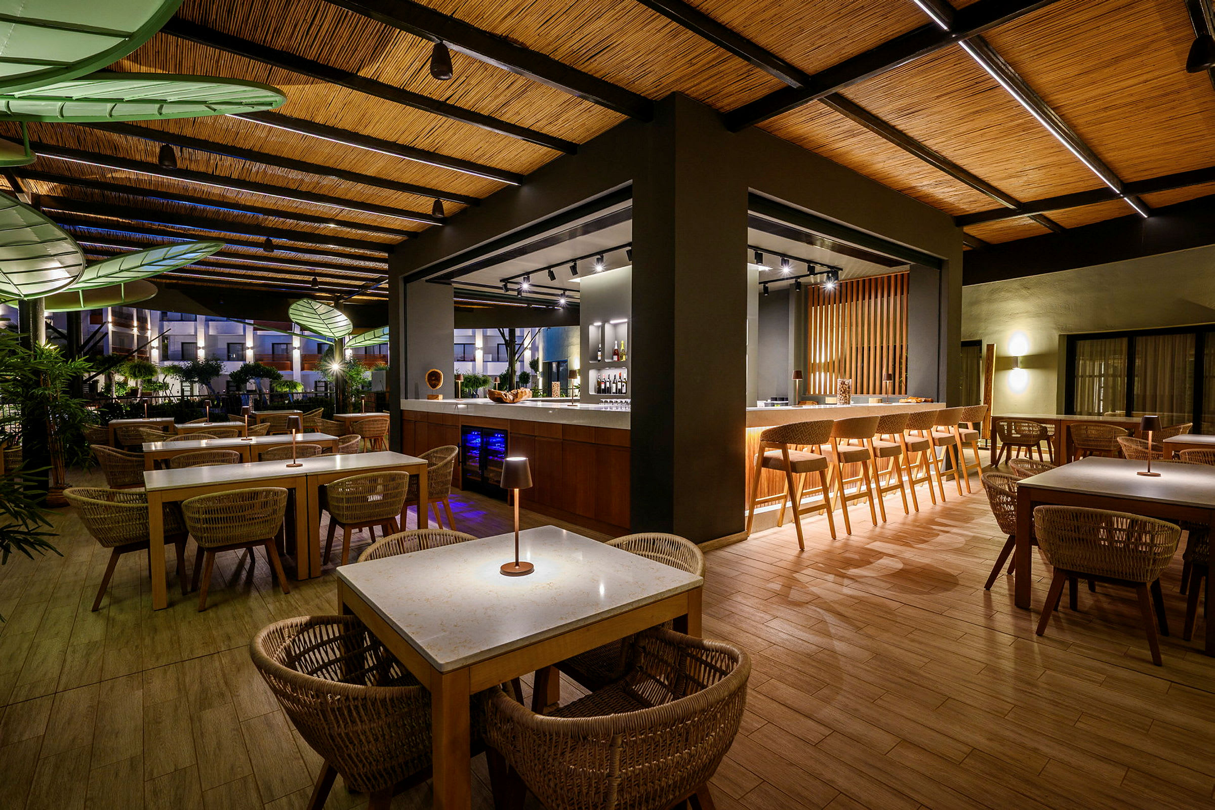 En hotellrestaurang med bord och stolar i trä samt en bardisk. (AI-genererad text)
