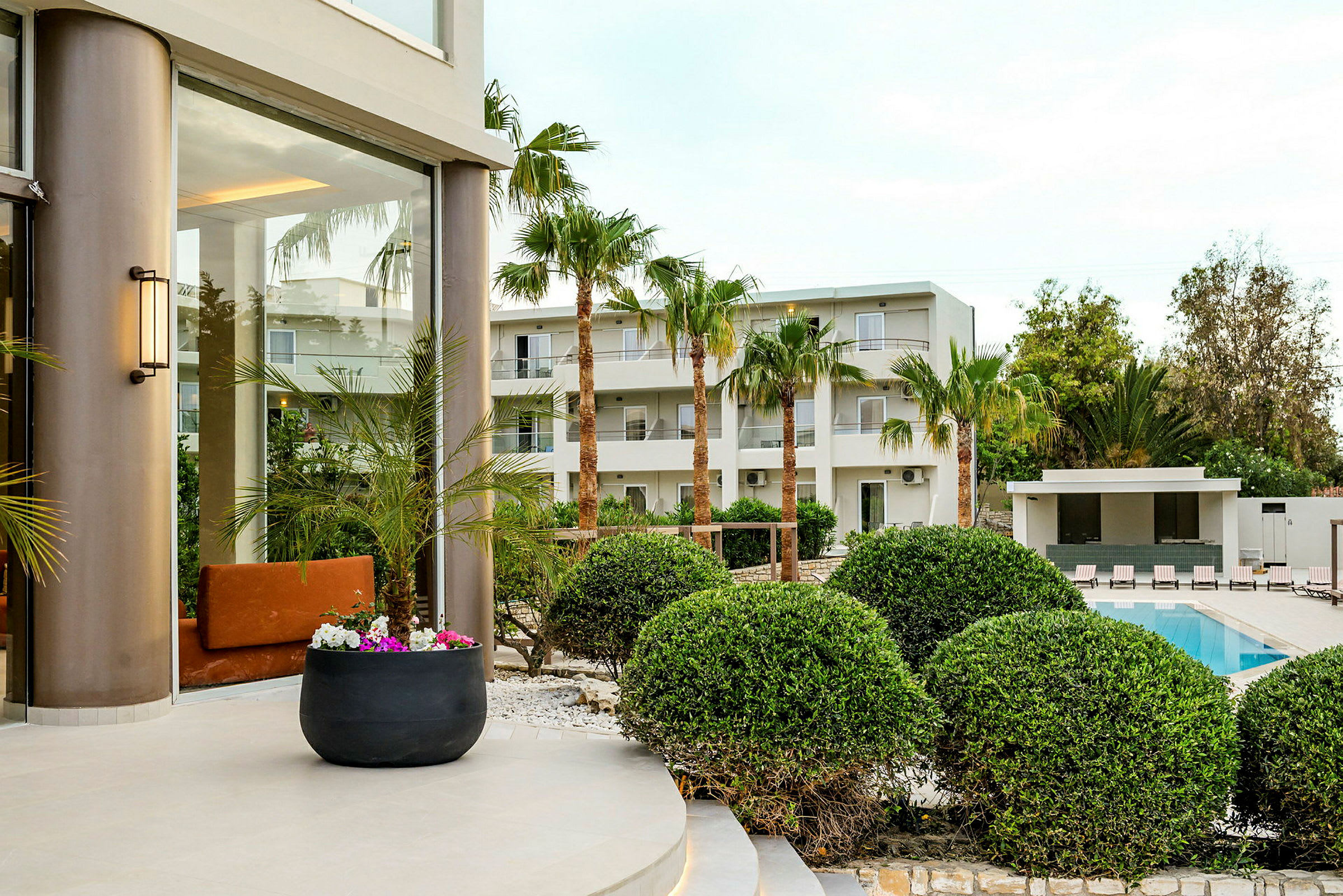 Hotellområde med palmer, pool och grönska. (AI-genererad text)