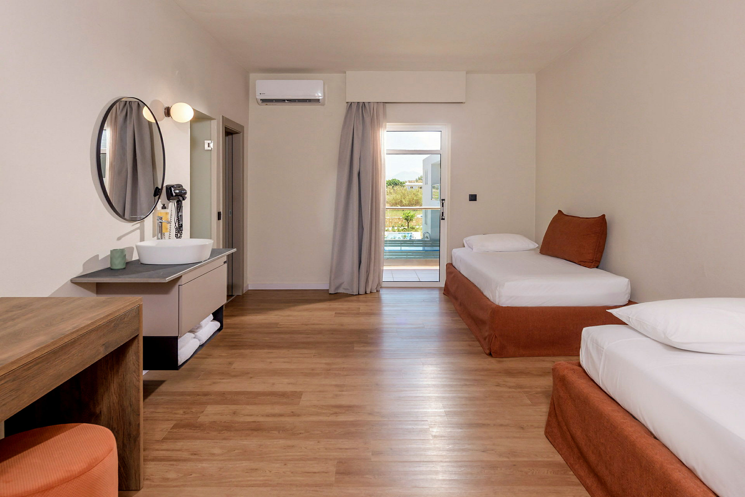 Ett hotellrum med två sängar och en utgång till en balkong. (AI-genererad text)