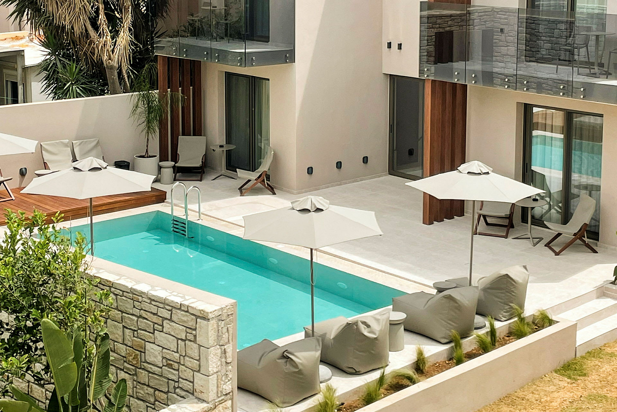 Modern hotellpool omgiven av solstolar och parasoller. (AI-genererad text)