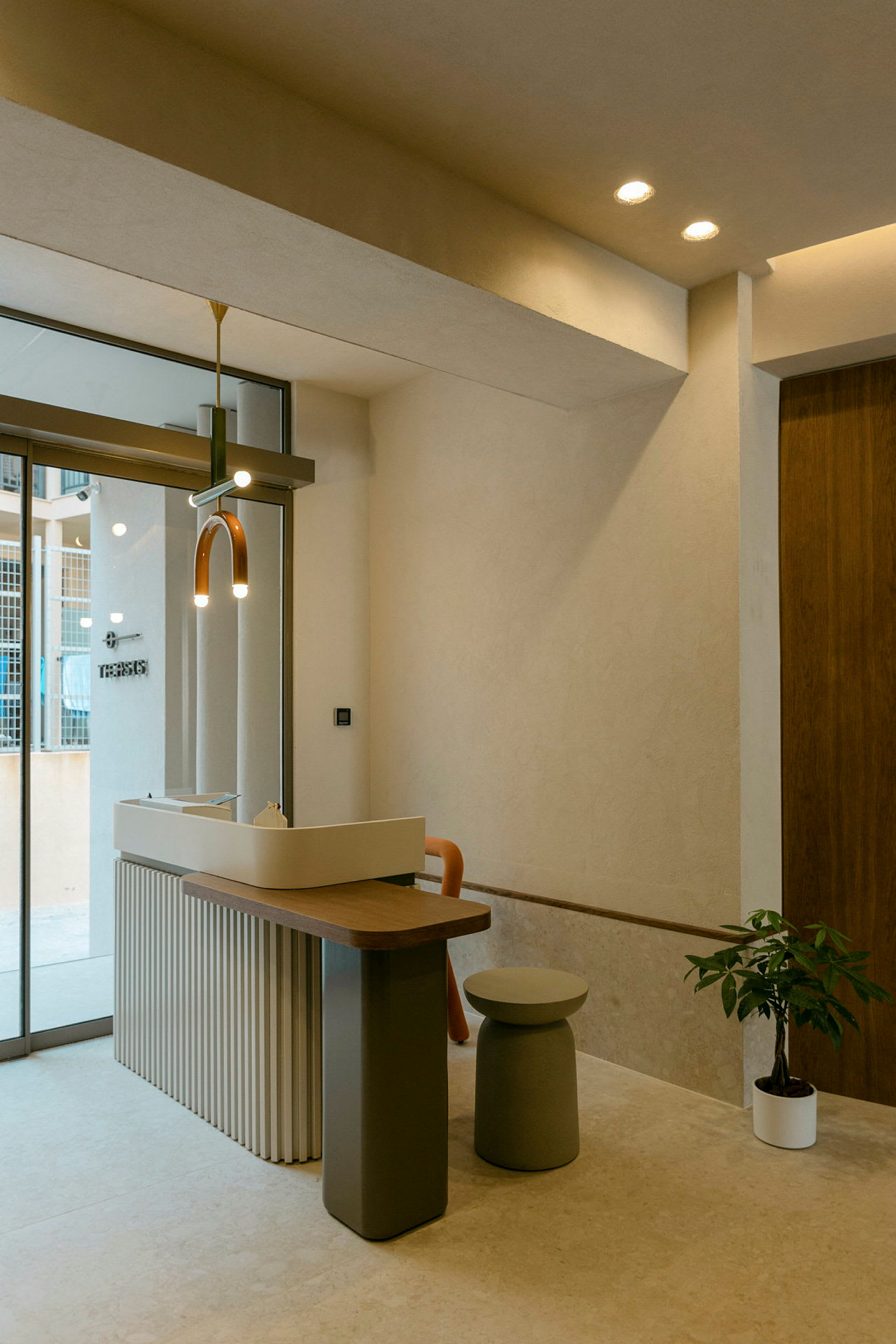 Interiör med modern reception, liten pall och krukväxt. (AI-genererad text)
