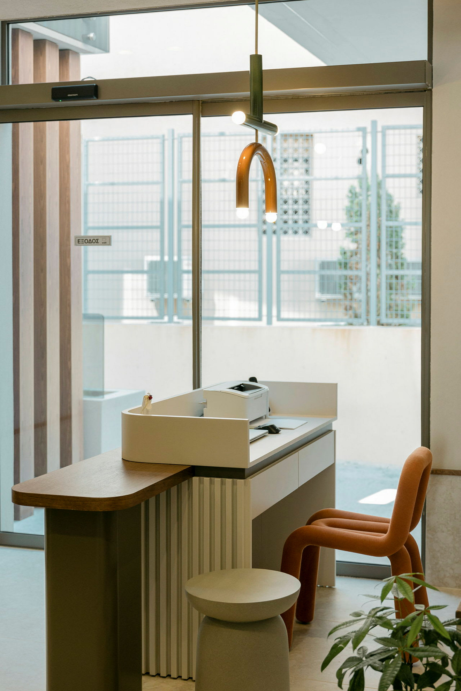 En receptionsmiljö med en skrivare på en disk och en modern stol. (AI-genererad text)