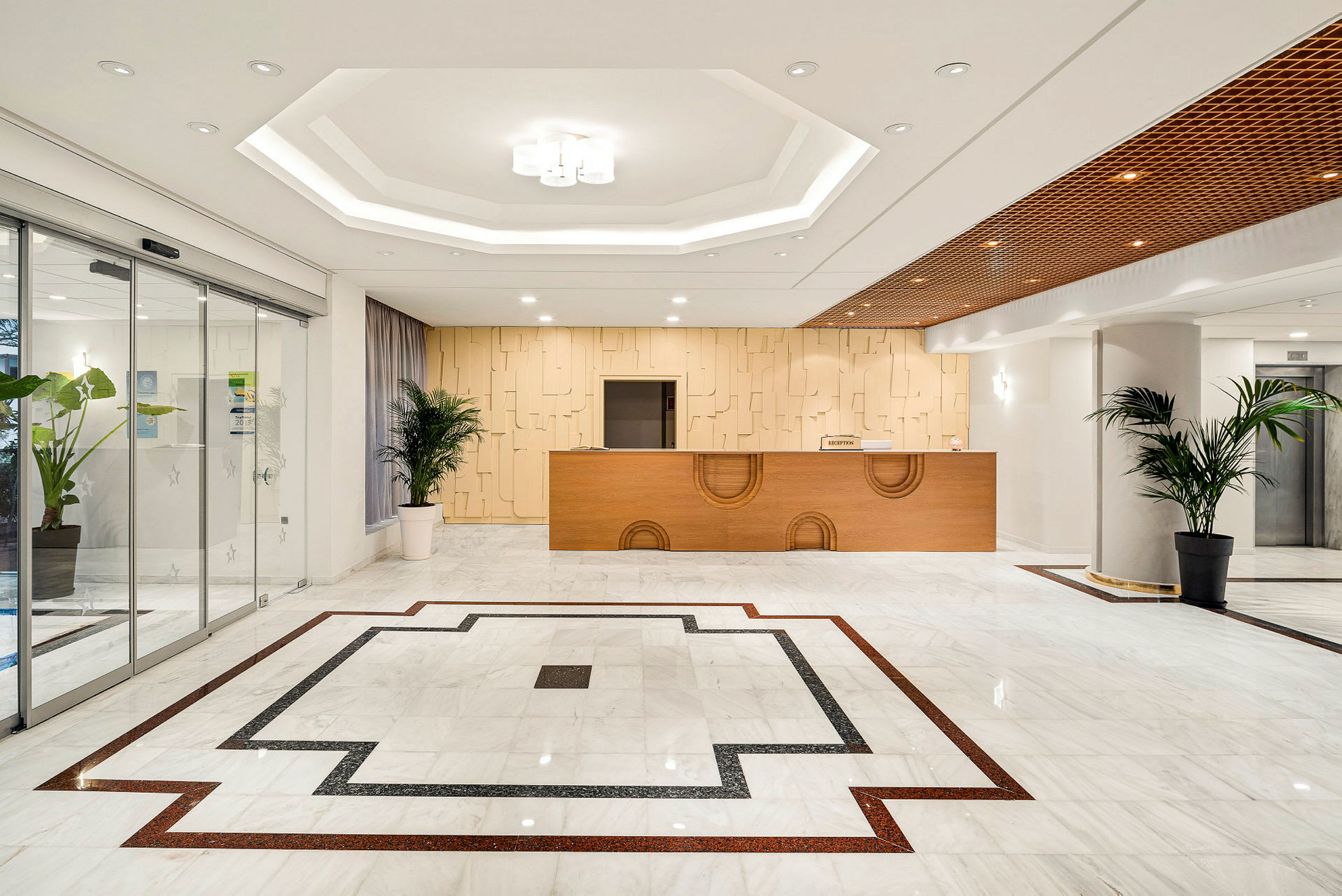 Hotellobby med receptionsdisk, marmorbeläggning och dekorativa växter. (AI-genererad text)