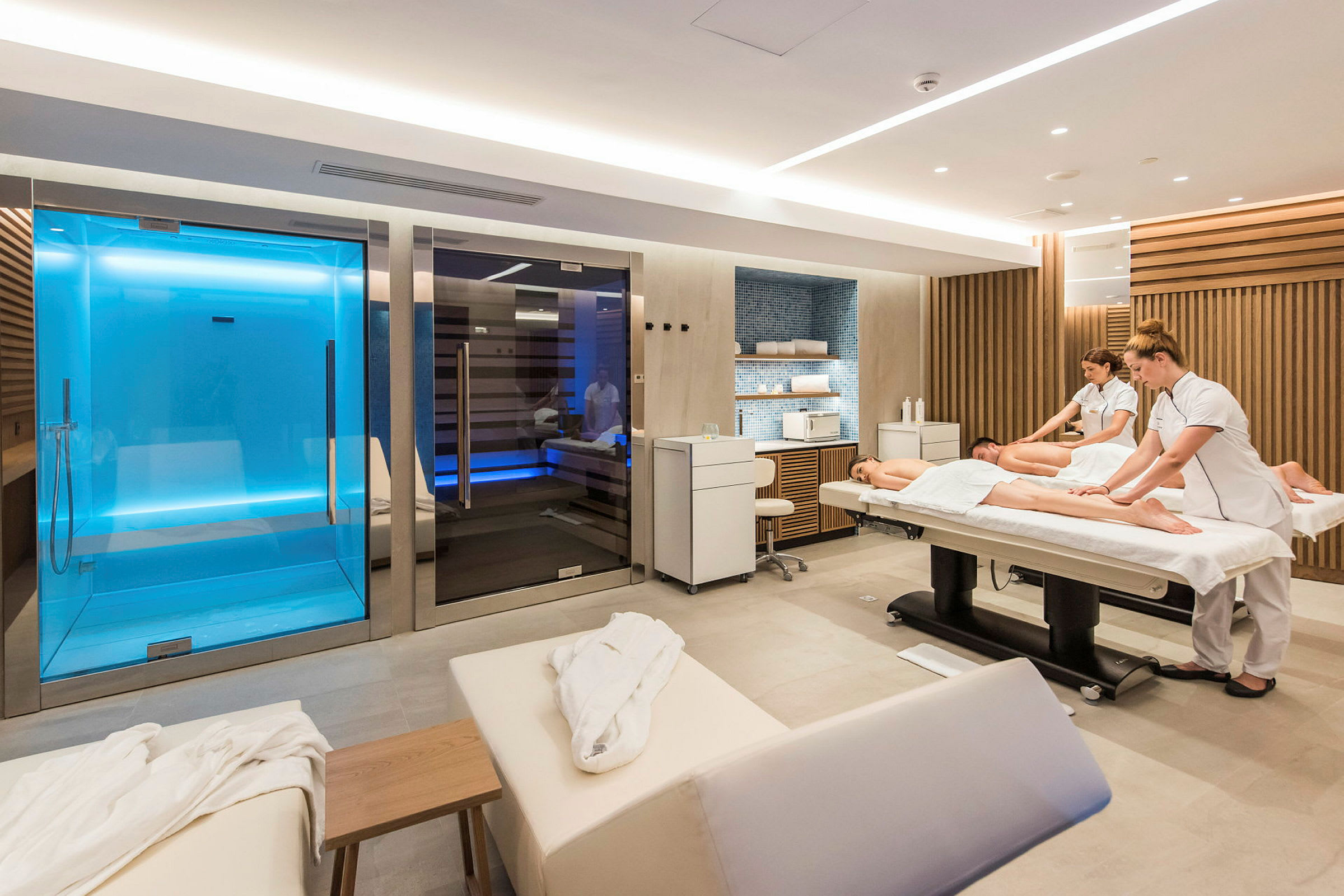 Ett modernt spa med massagebord och bastuområde. (AI-genererad text)