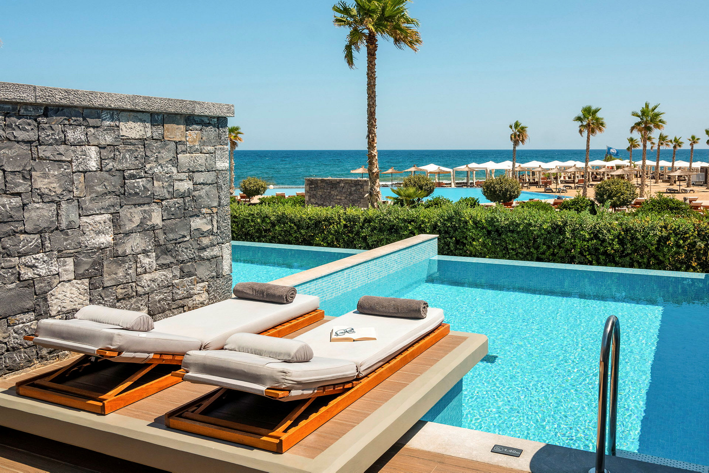 Solstolar vid en privat pool med havsutsikt. (AI-genererad text)