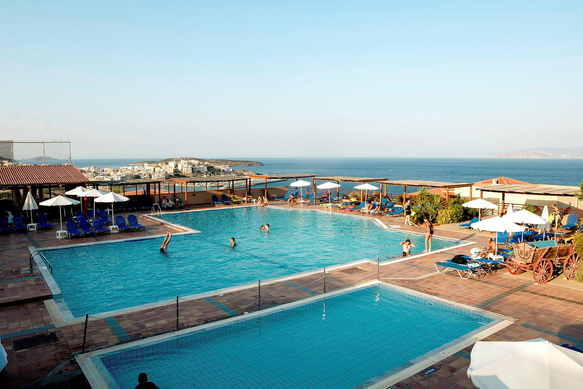 Utomhuspool vid ett hotell med havsutsikt i bakgrunden. (AI-genererad text)