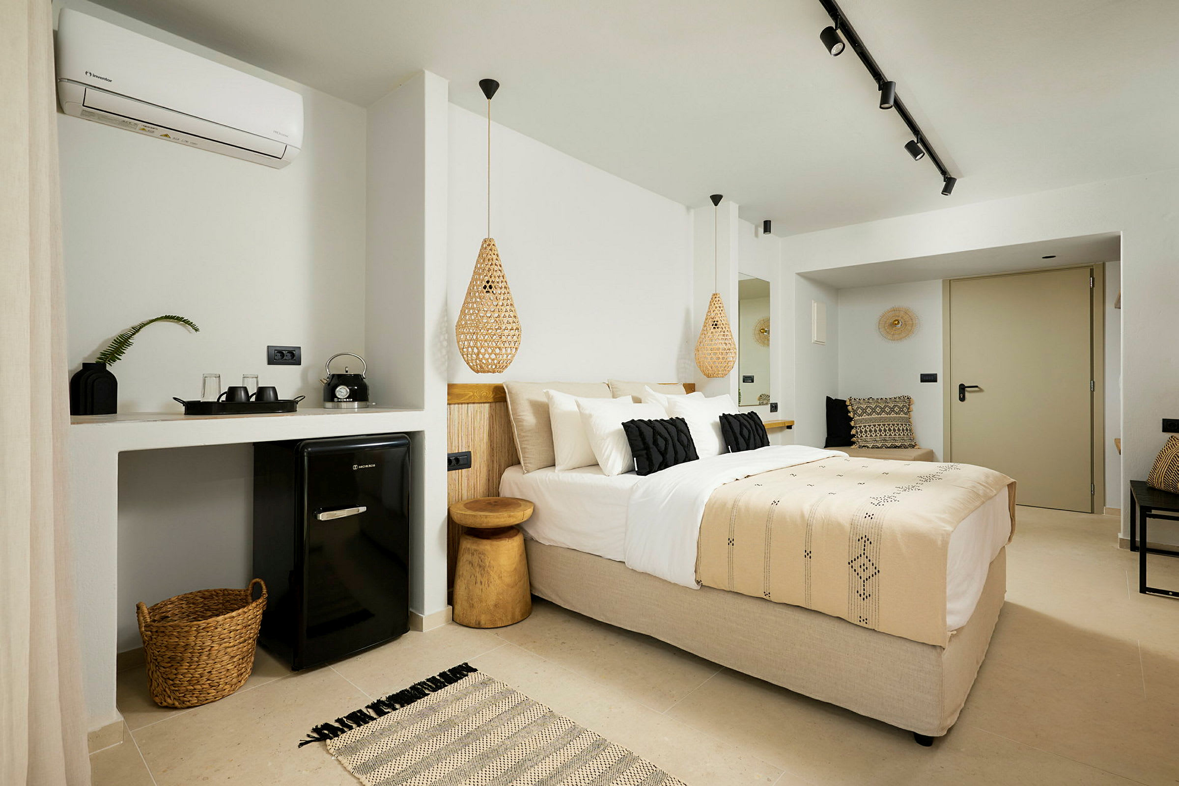 Ett modernt hotellrum med en dubbelsäng, små detaljer och ett minibarområde. (AI-genererad text)